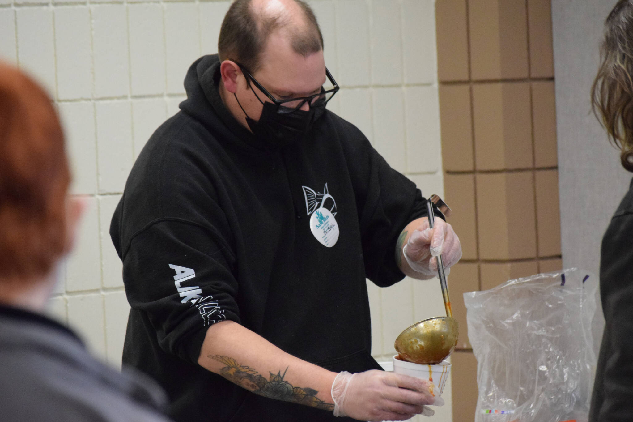 University of Alaska Anchorage human services intern Zachary Boyle serves lunch during the Project Homeless Connect event Soldotna Regional Sports Complex in Soldotna on Wednesday, Jan. 26, 2022. (Camille Botello/Peninsula Clarion)