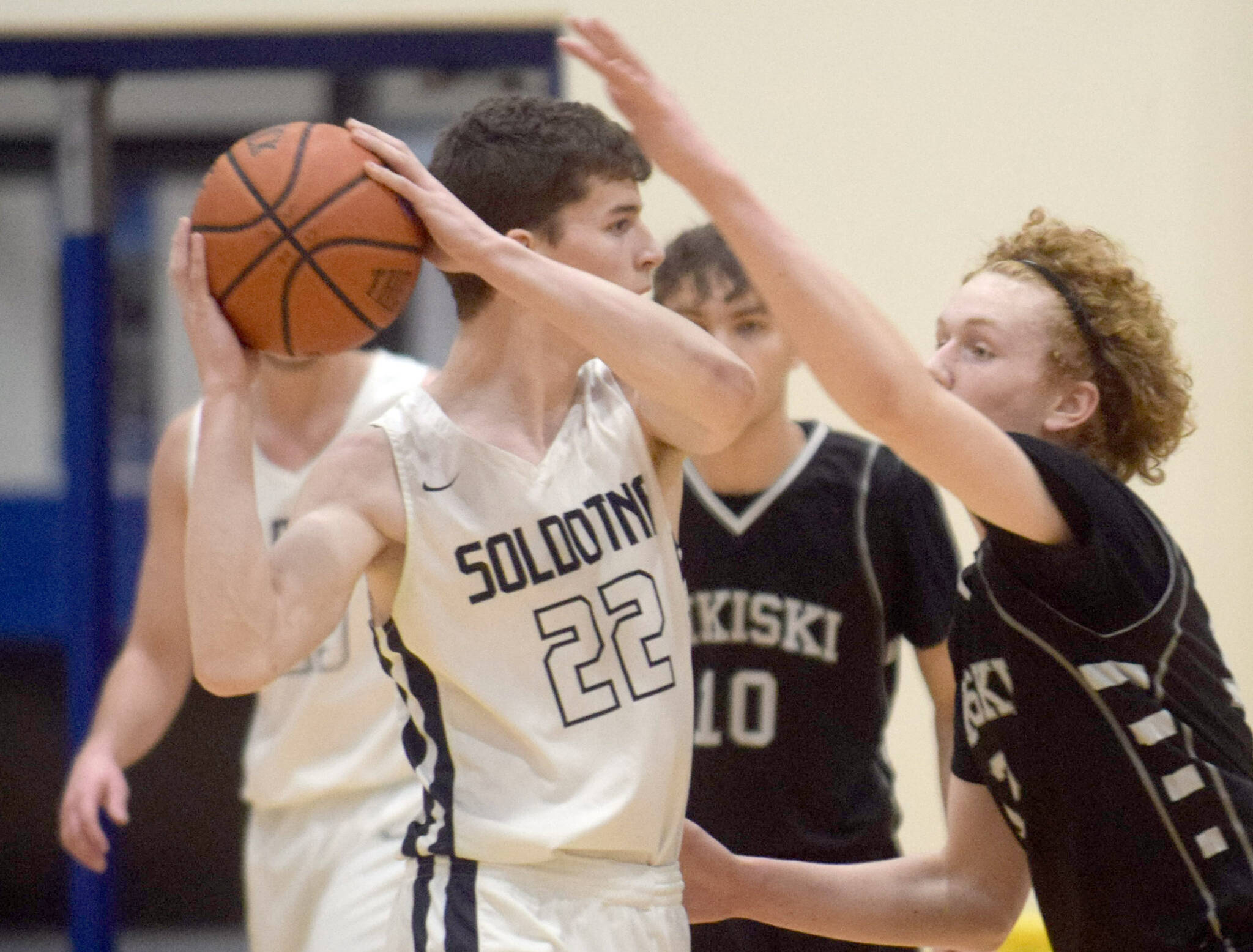 Soldotna’s Ethan Sewell handles pressure from Nikiski’s Brady Bostic on Tuesday, Feb. 8, 2022, at Soldotna High School in Soldotna, Alaska. (Photo by Camille Botello/Peninsula Clarion)