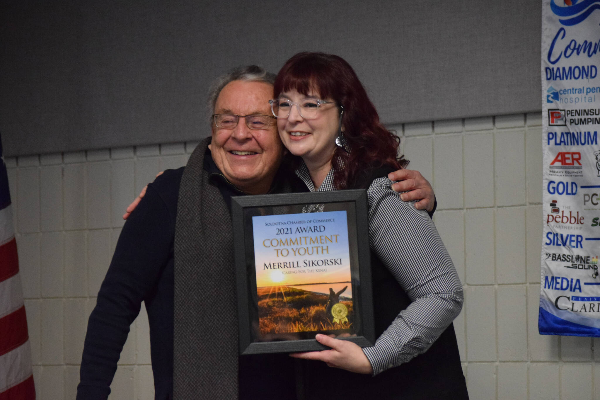 Merrill Sikorski accepts the Soldotna Chamber of Commerce’s commitment to youth award from Sara Hondel for his work with the Caring for the Kenai ecological competition during the chamber’s 2021 award ceremony at the Soldotna Regional Sports Complex on Wednesday, Feb. 9, 2022. (Camille Botello/Peninsula Clarion)