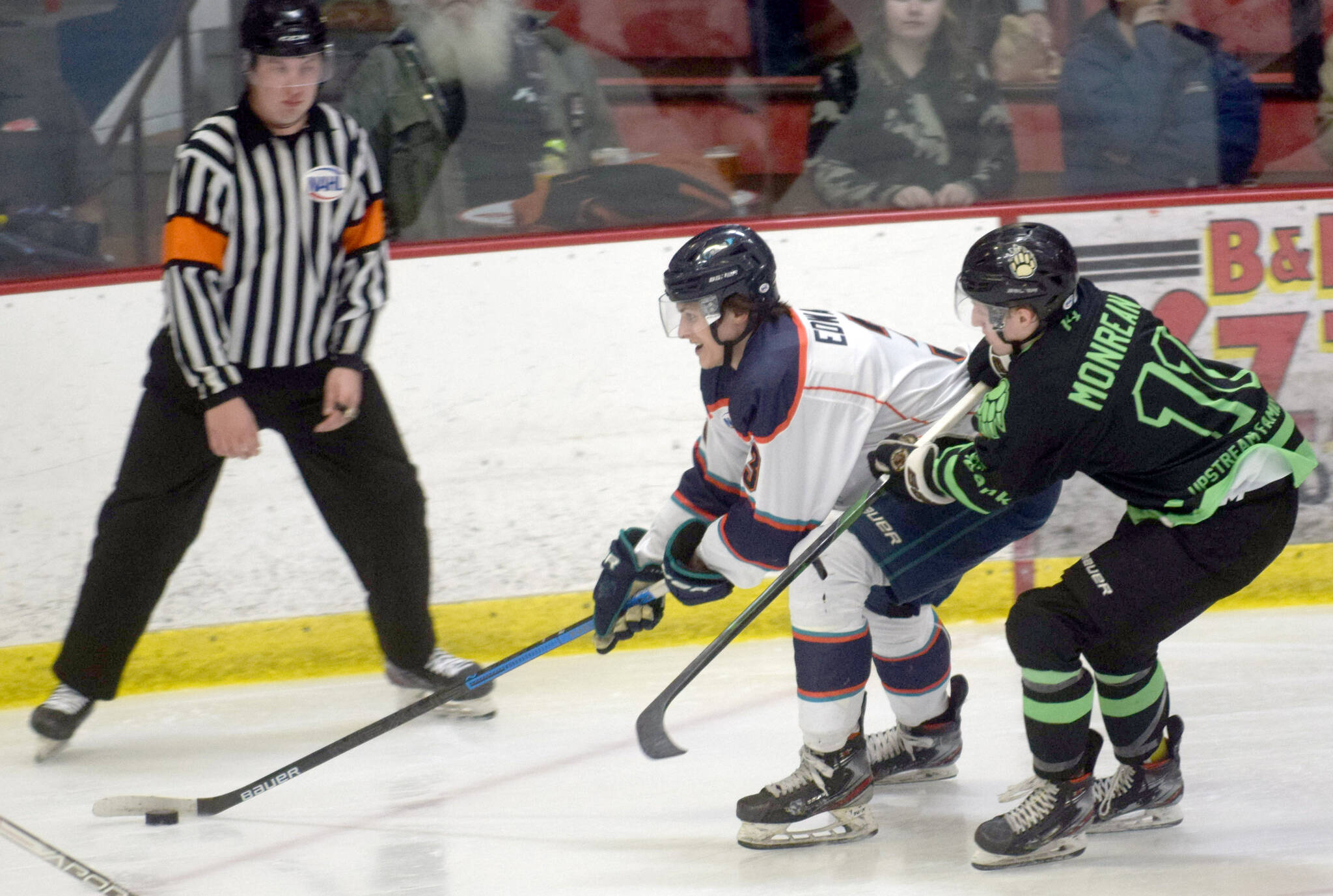 Anchorage Wolverines defenseman Ben Edwards shields the puck from Kenai River Brown Bears forward Bryce Monrean on Friday, Feb. 18, 2022, at the Soldotna Regional Sports Complex in Soldotna, Alaska. (Photo by Camille Botello/Peninsula Clarion)