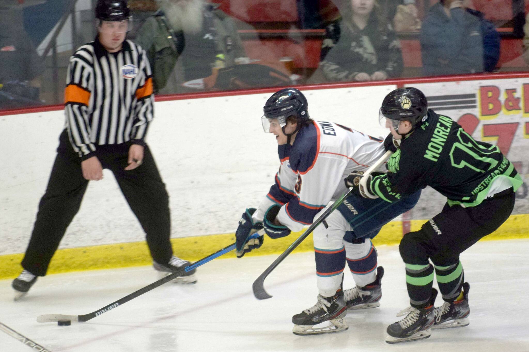 Anchorage Wolverines defenseman Ben Edwards shields the puck from Kenai River Brown Bears forward Bryce Monrean on Friday, Feb. 18, 2022, at the Soldotna Regional Sports Complex in Soldotna, Alaska. (Photo by Camille Botello/Peninsula Clarion)