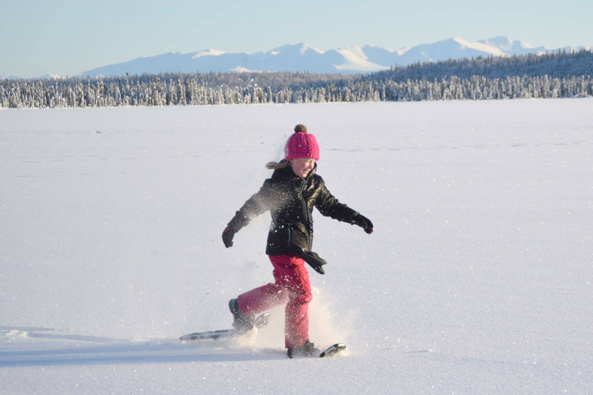 Drew Slegers, a fourth grader at Soldotna Elementary, snowshoes on Headquarters Lake in the Kenai National Wildlife Refuge just outside of Soldotna, Alaska, on Tuesday, Dec. 21, 2021. The refuge is offering spring break snowshoe walks for kids. (Photo by Jeff Helminiak/Peninsula Clarion)