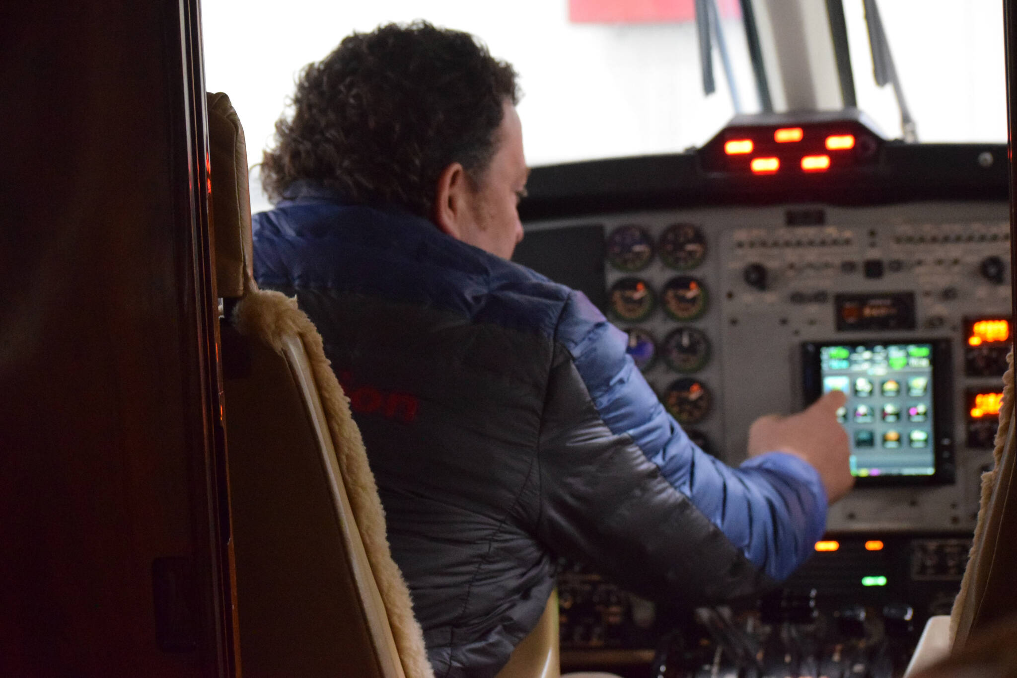 Joel Caldwell, director of operations for Kenai Aviation, sits in the pilot’s seat of Kenai Aviation’s nine-seat Beechcrafter Super King Air B200 plane in Kenai, Alaska, on Wednesday, March 9, 2022. (Camille Botello/Peninsula Clarion)