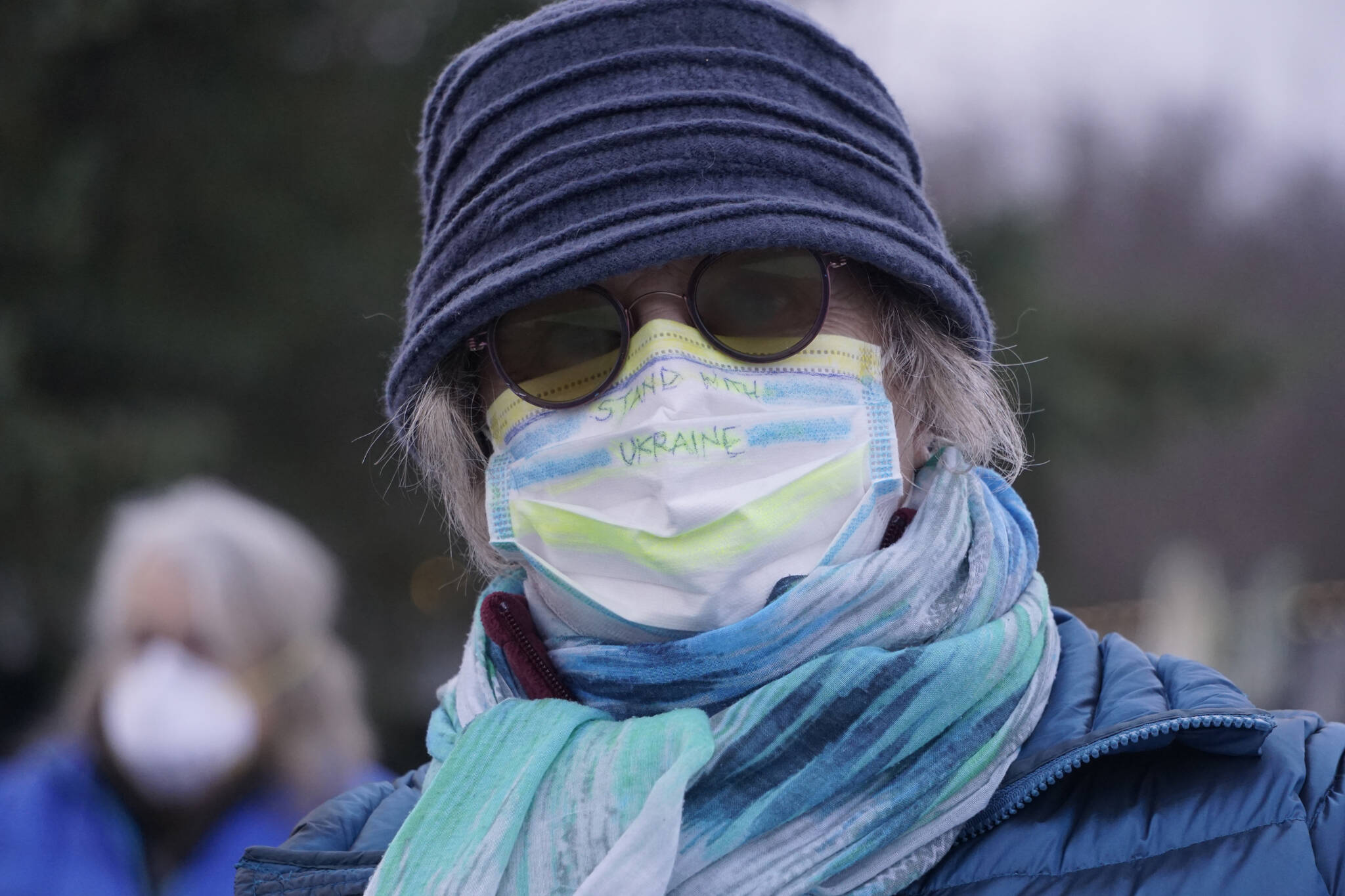 Susan Cushing wears a facemask saying “Stand With Ukraine” at a demonstration in support of Ukraine on Thursday, March 3, 2022, at WKFL Park in Homer, Alaska. (Photo by Michael Armstrong/Homer News)