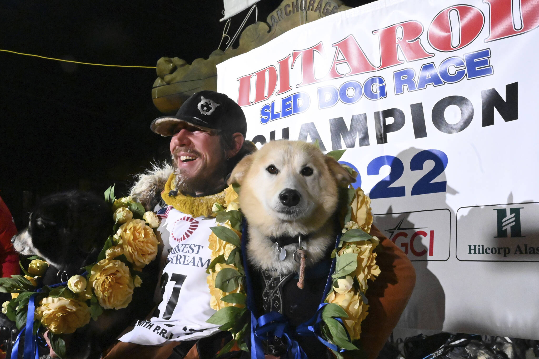 Iditarod winner Brent Sass poses for photos with lead dogs Morello, left, and Slater in the finish chute of the Iditarod Trail Sled Dog Race in Nome, Alaska, Tuesday March 15, 2022. (Anne Raup/Anchorage Daily News via AP)