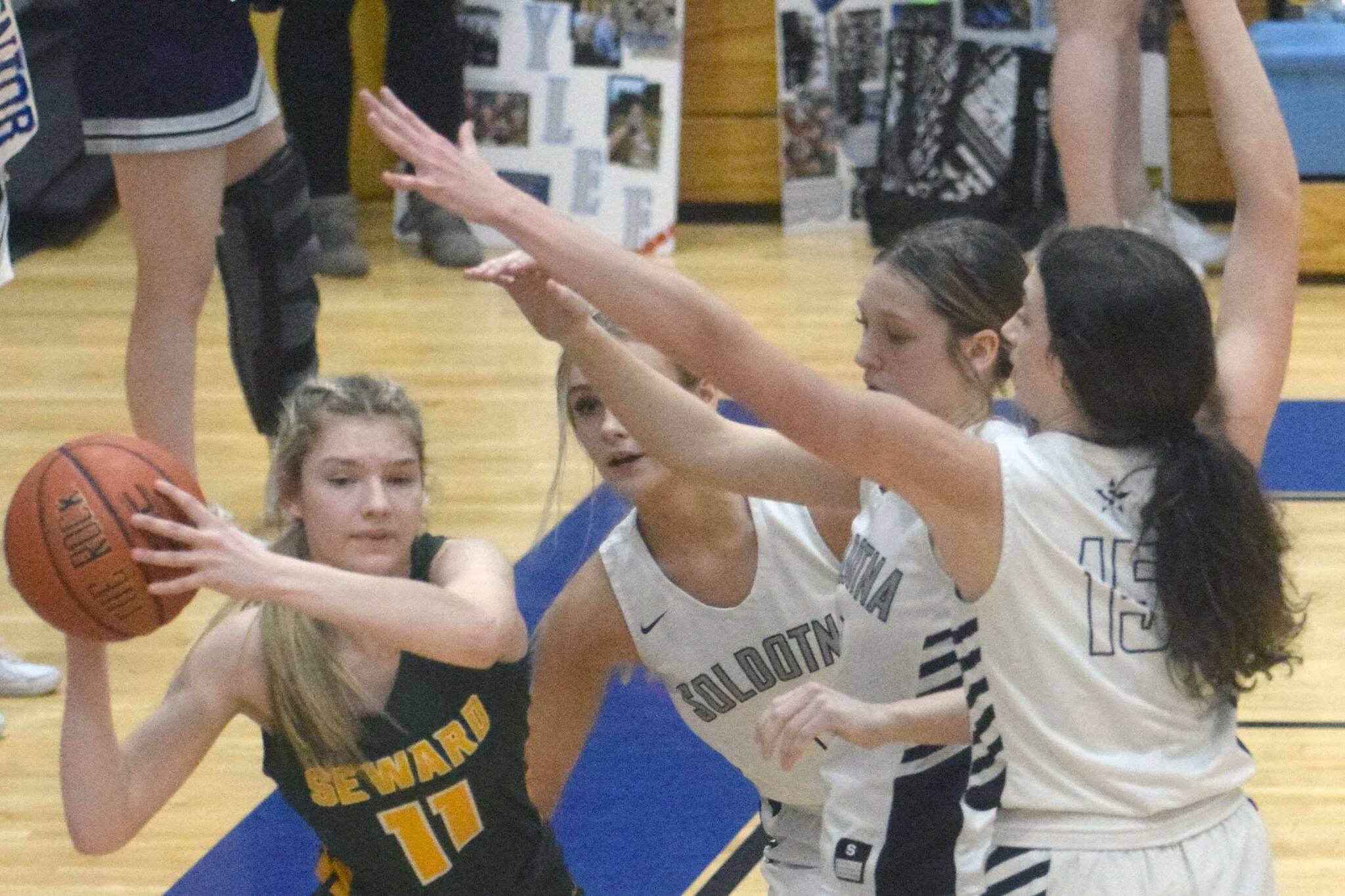 Seward’s Lena Jagielski passes under pressure from Jolie Widaman, Katelyn Morrison and Adarra Hagelund on Thursday, March 3, 2022, at Soldotna High School in Soldotna, Alaska. (Photo by Jeff Helminiak/Peninsula Clarion)