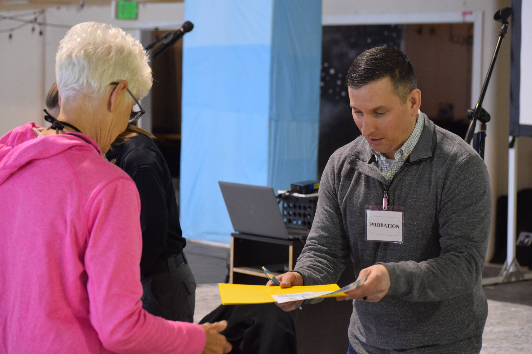 A participant seeks probation services at the Kenai Peninsula Re-Entry Coalition simulation at the Old Carrs Mall in Kenai, Alaska, on Saturday, April 2, 2022. The event was intended to give community members an understanding of the challenges faced by those leaving incarceration. (Camille Botello/Peninsula Clarion)