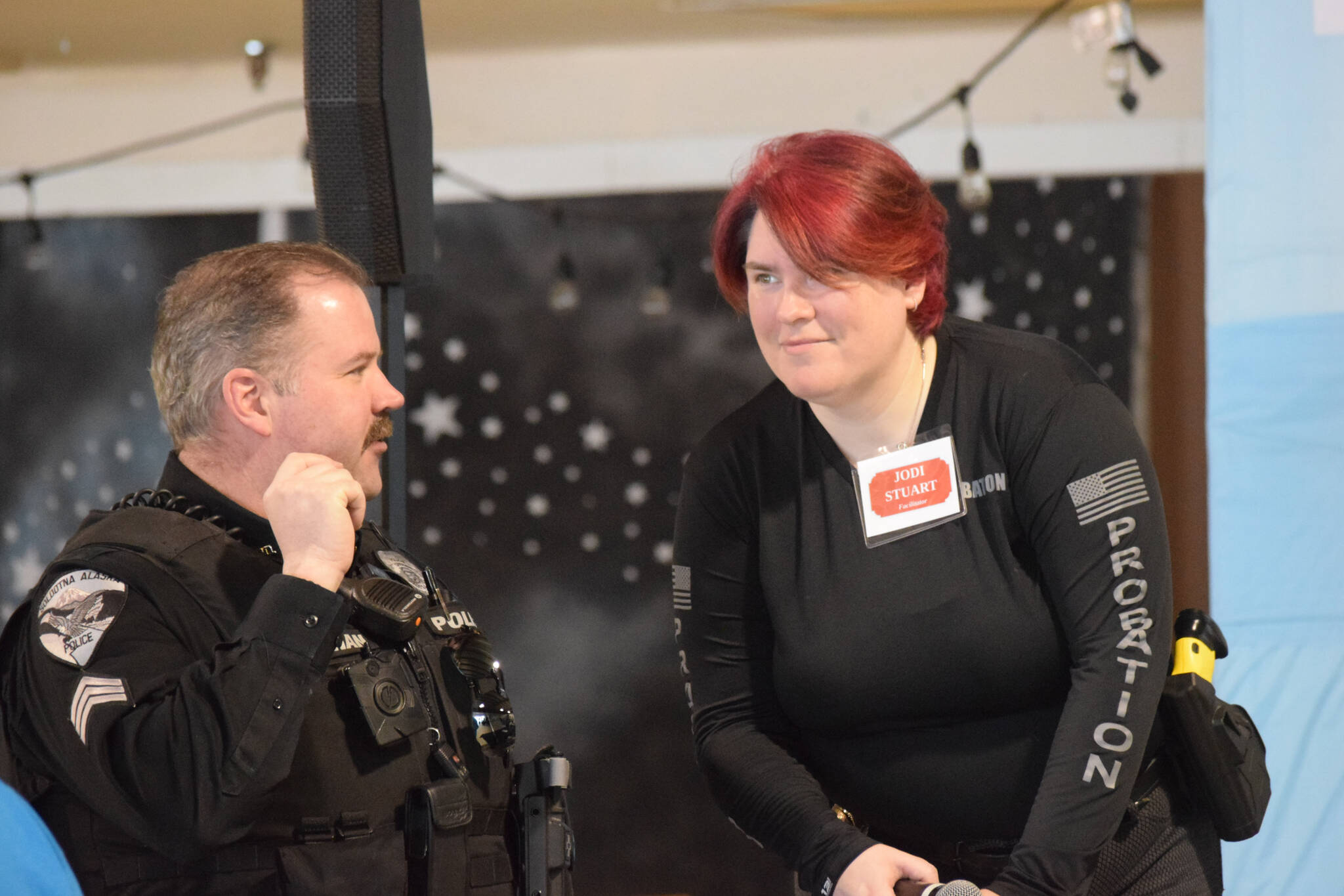 Jodi Stuart, right, talks to a participant at the Kenai Peninsula Re-Entry Coalition simulation at the Old Carrs Mall in Kenai, Alaska, on Saturday, April 2, 2022. (Camille Botello/Peninsula Clarion)