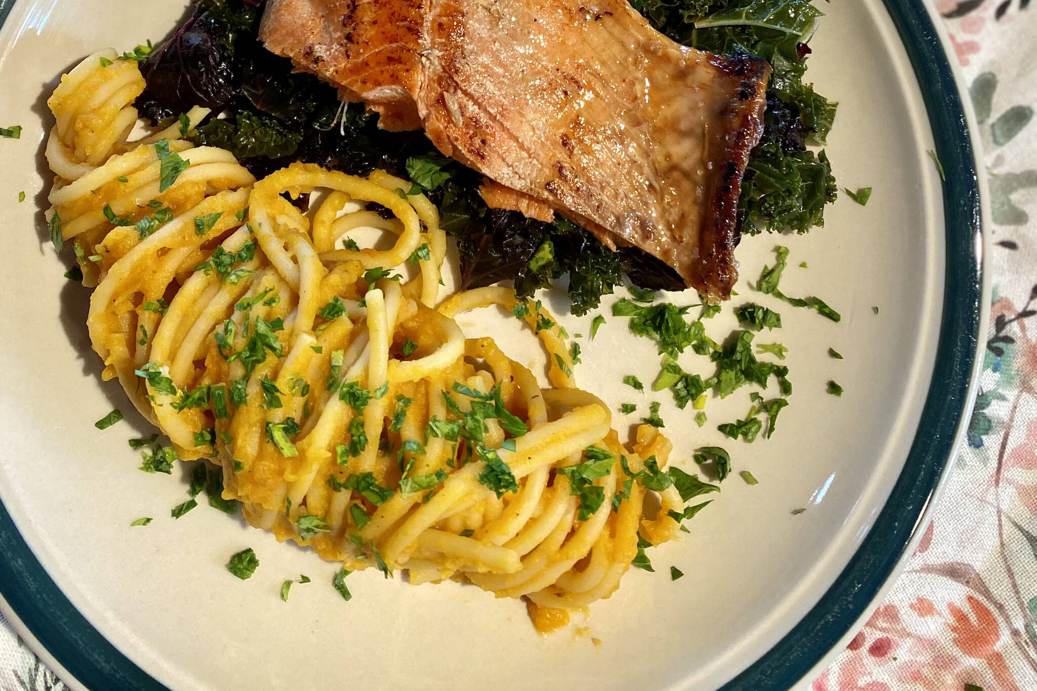 Creamy butternut squash pasta that skips the dairy is served with salmon and greens. (Photo by Tressa Dale/Peninsula Clarion)