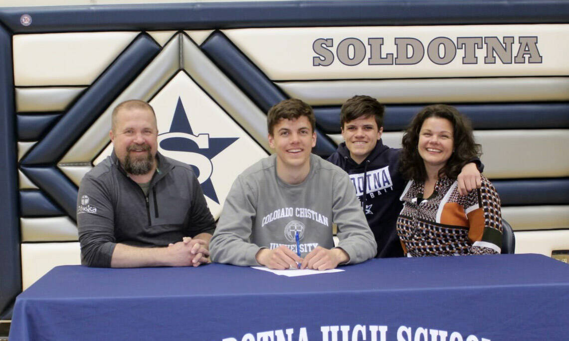 Nate Johnson signs his National Letter of Intent on Friday, April 22, 2022, at Soldotna High School in Soldotna, Alaska. From left to right are Nate’s father, Eric; Nate; Nate’s brother, Wesley; and Nate’s mother, Meghan. (Photo provided)