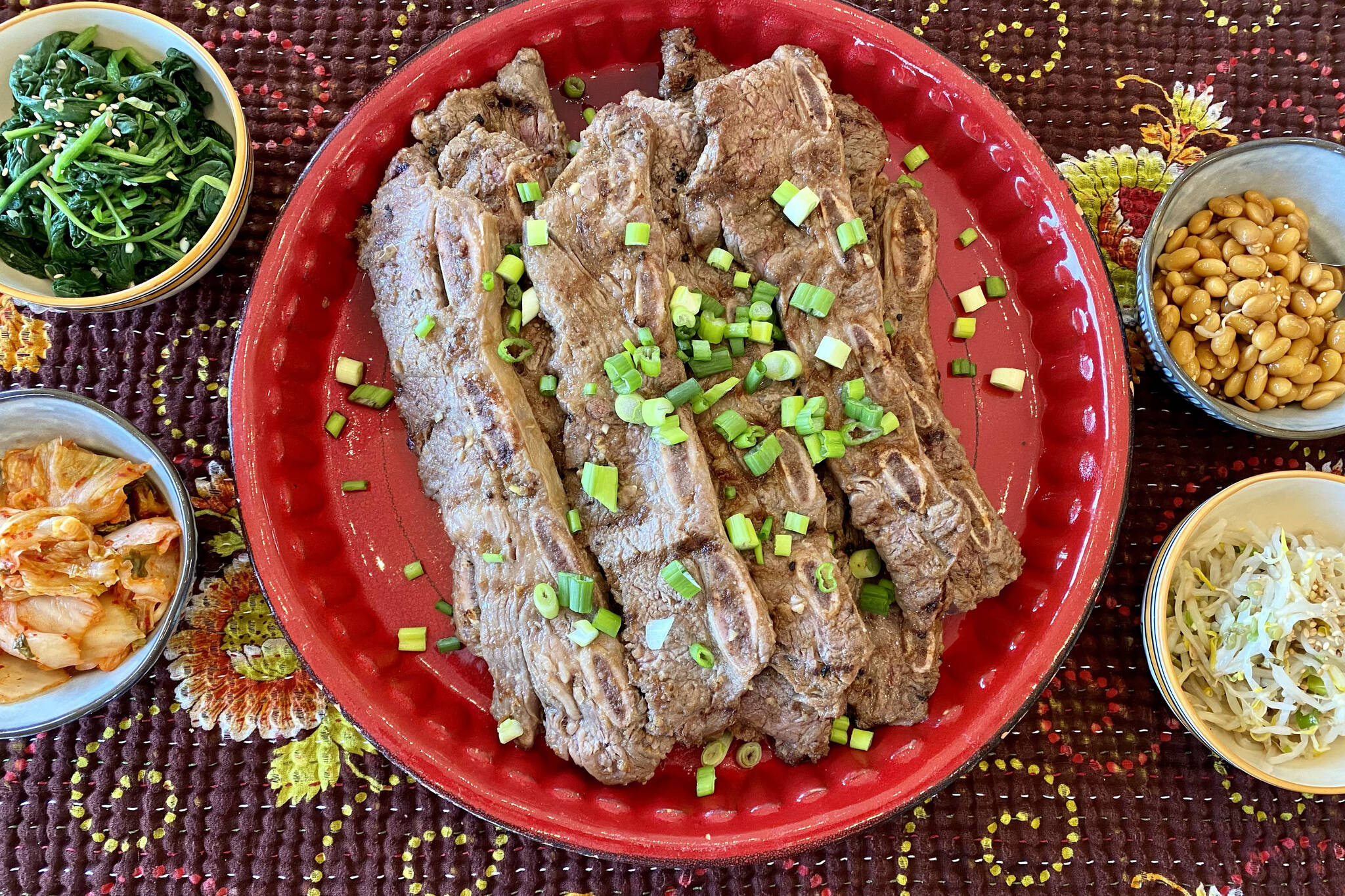 Kalbi ribs can be served with an assortment of side dishes, including white rice, kimchi, roasted garlic cloves, broccoli salad, dumplings and soup. (Photo by Tressa Dale/Peninsula Clarion)