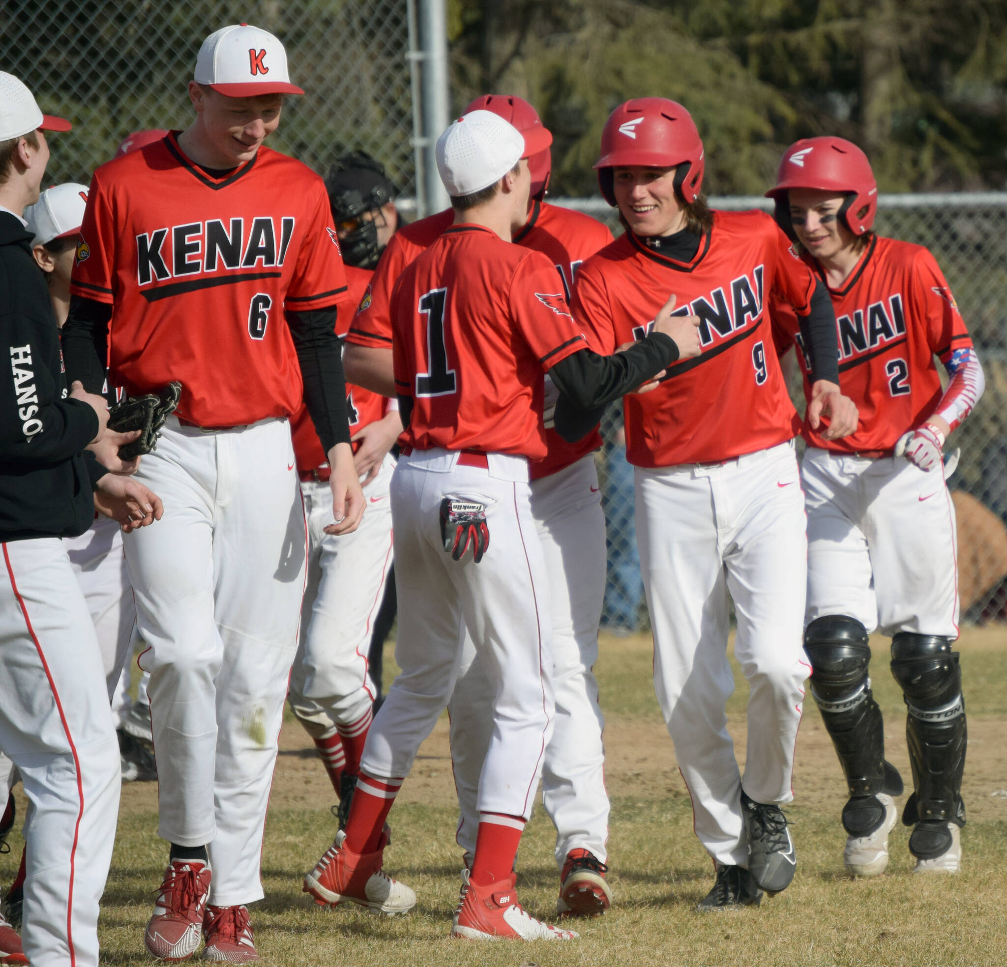 Kenai Central’s Simon Grenier (9) celebrates his grand slam against Soldotna with teammates at the Soldotna Little League fields Wednesday, May 4, 2022, in Soldotna, Alaska. (Photo by Jeff Helminiak/Peninsula Clarion)