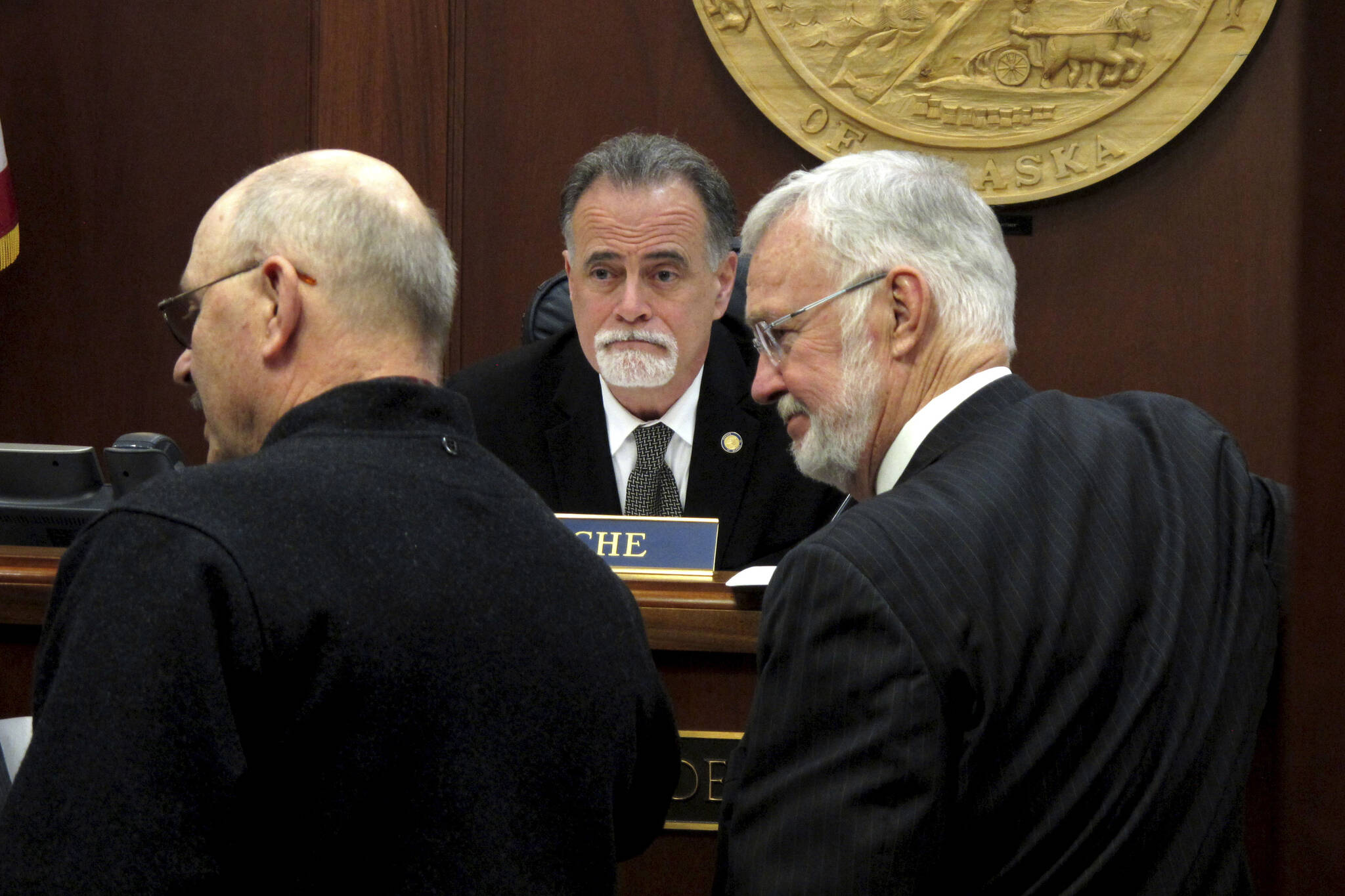 Alaska state Senate President Peter Micciche, center, looks on as lawmakers gather in front of him on the Senate floor on Wednesday, May 4, 2022, in Juneau, Alaska. A bill dealing with the annual dividend paid to residents was bumped from the Senate floor on Wednesday. Micciche said it did not have the votes to pass. (AP Photo/Becky Bohrer)