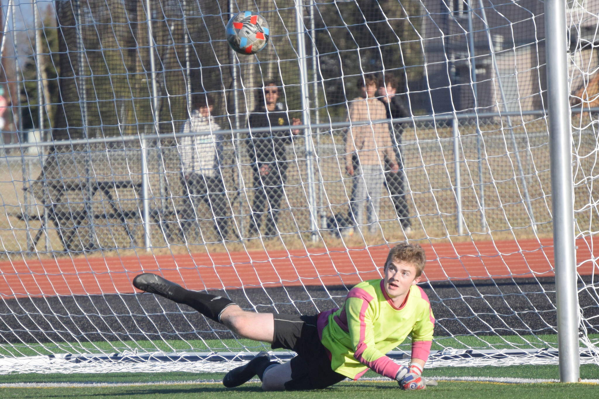 Kenai Central goalie Gavin Langham saves a penalty kick against Dimond on Friday, May 6, 2022, at Ed Hollier Field at Kenai Central High School in Kenai, Alaska. (Photo by Jeff Helminiak/Peninsula Clarion)