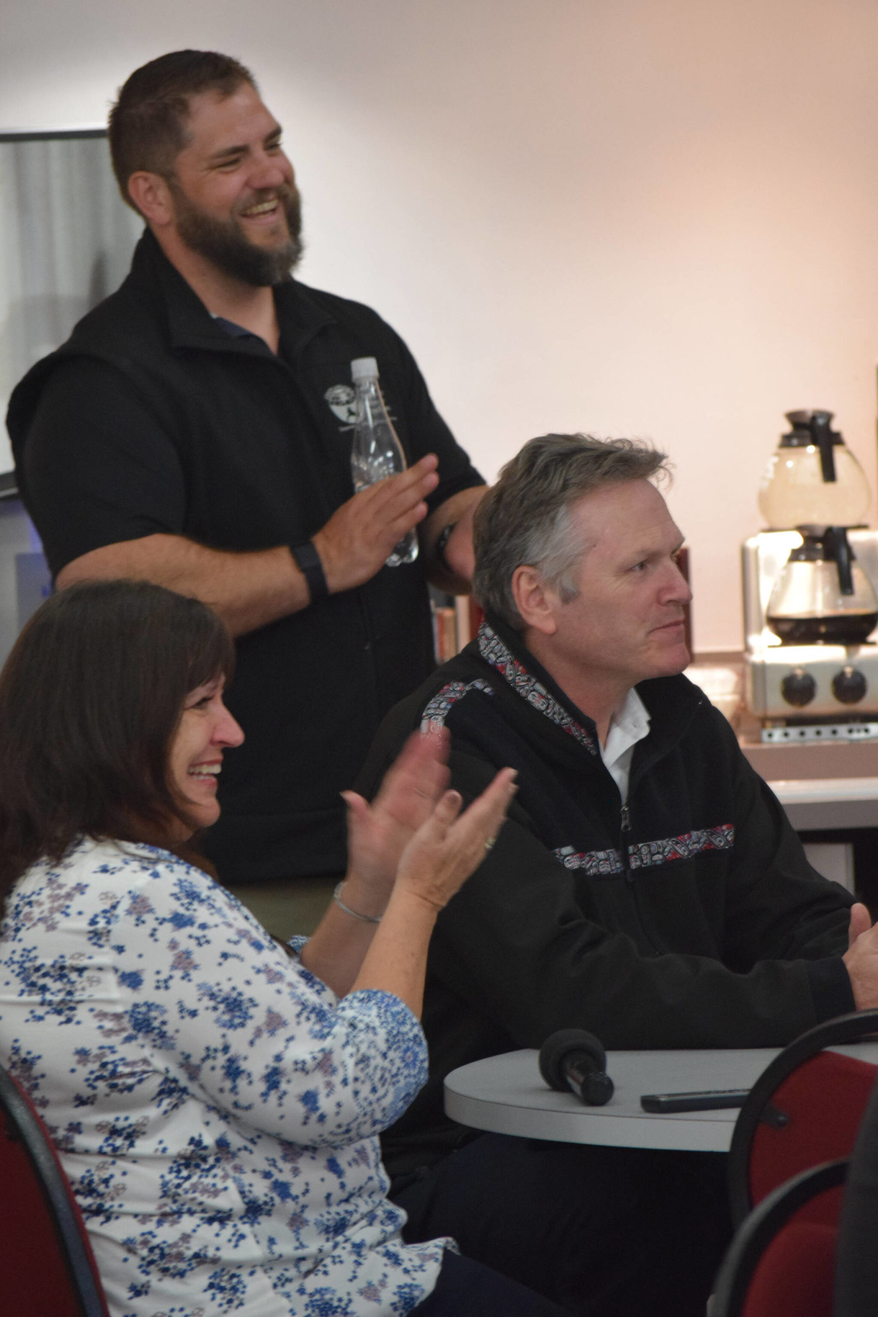 Alaska Department of Health and Social Services Commissioner Adam Crum, Soldotna Senior Center Executive Director Loretta Knudson-Spalding and Alaska Gov. Mike Dunleavy attend a Meals on Wheels event at the Soldotna Senior Center on Friday, May 6, 2022. (Camille Botello/Peninsula Clarion)