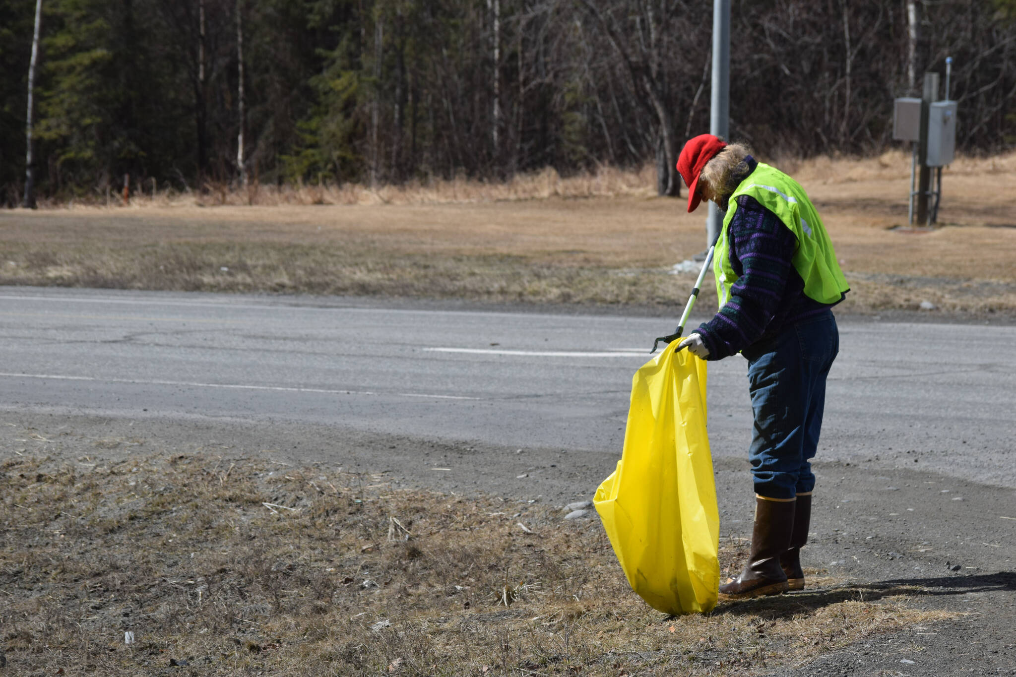 Friends of Alaska National Wildlife Refuge Vice President and Outreach Chair Poppy Benson collects litter from the side of the highway at the refuge in Soldotna, Alaska on Friday, April 30, 2021. (Camille Botello/Peninsula Clarion)