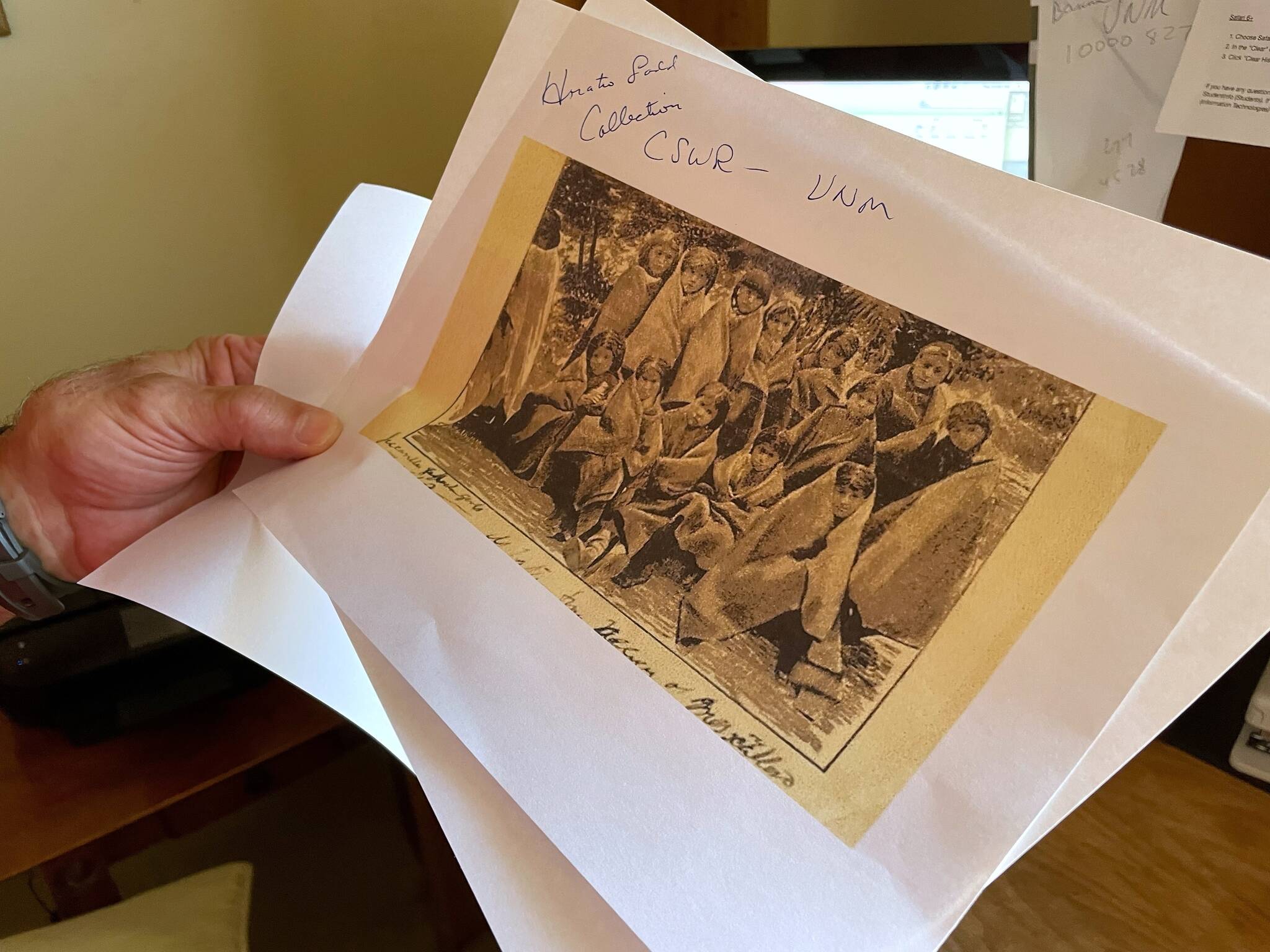 In this July 8, 2021, photo, adjunct history professor and research associate Larry Larrichio holds a copy of a late 19th century photograph of pupils at an Indigenous boarding school in Santa Fe during an interview in Albuquerque, New Mexico. The U.S. Interior Department is expected to release a report Wednesday, May 11, 2022, that it says will begin to uncover the truth about the federal government’s past oversight of Native American boarding schools. (AP Photo/Susan Montoya Bryan, File)