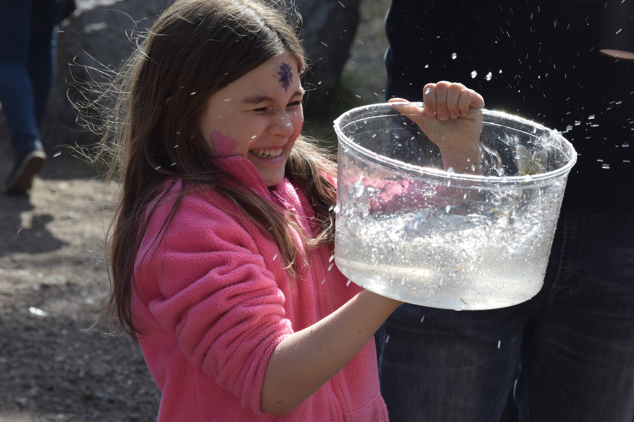 Presley Jackson waits in line before releasing her rainbow trout at the 21st annual Kenai Peninsula Salmon Celebration in Kasilof on Wednesday, May 11, 2022. (Camille Botello/Peninsula Clarion)
