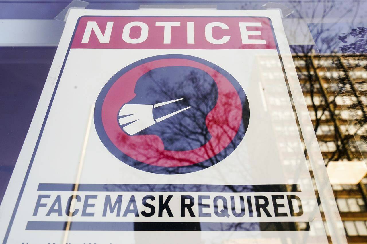 FILE - A sign requiring masks as a precaution against the spread of the coronavirus on a store front in Philadelphia, is seen Feb. 16, 2022. Philadelphia is reinstating its indoor mask mandate after reporting a sharp increase in coronavirus infections, Dr. Cheryl Bettigole, the city’s top health official, announced Monday, April 11, 2022. Confirmed COVID-19 cases have risen more than 50% in 10 days, the threshold at which the city’s guidelines call for people to wear masks indoors. (AP Photo/Matt Rourke, File)