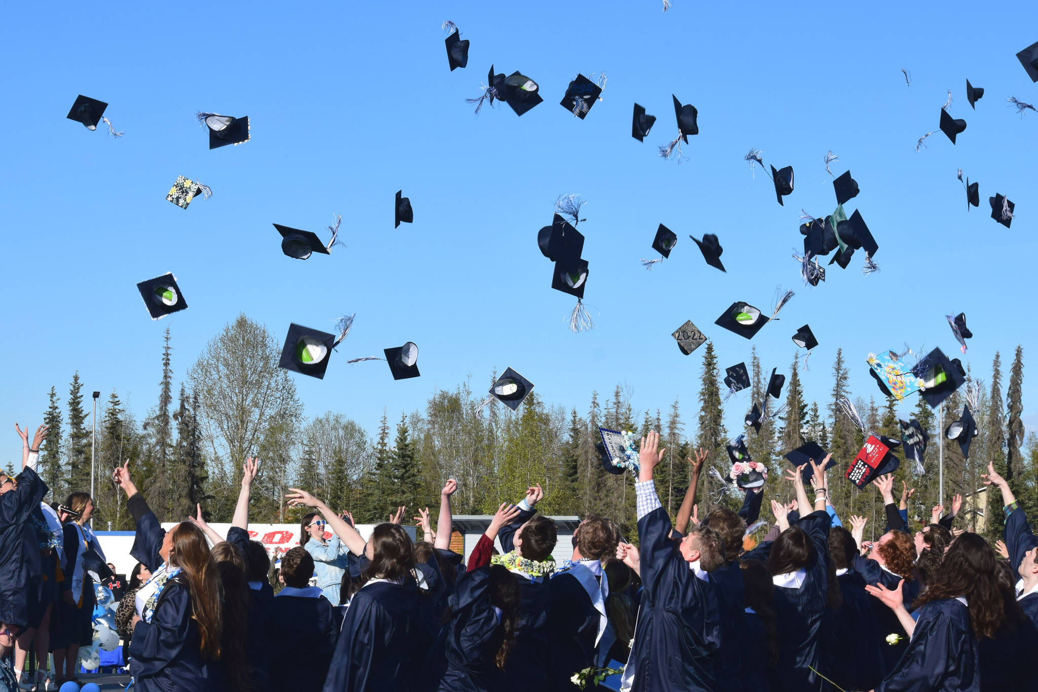 Graduates throw their caps into the air at the end of Soldotna High School’s commencement ceremony on Wednesday, May 18, 2022, in Soldotna, Alaska. (Ashlyn O’Hara/Peninsula Clarion)