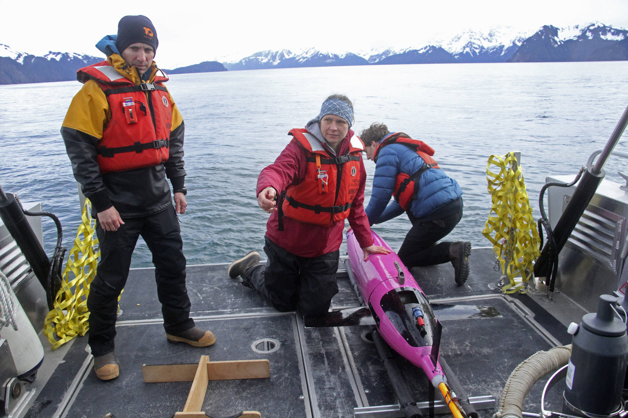 This May 4, 2022, photo shows oceanographers Andrew McDonnell, left, and Claudine Hauri, middle, along with engineer Joran Kemme after an underwater glider was pulled aboard the University of Alaska Fairbanks research vessel Nanuq from the Gulf of Alaska. The glider was fitted with special sensors to study ocean acidification. (AP Photo/Mark Thiessen)