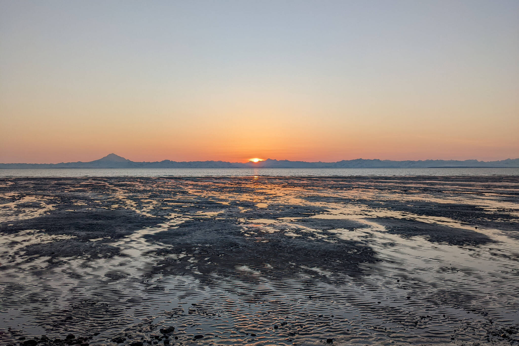 Mount Redoubt volcano can be seen across Cook Inlet from the shores of South Kenai Beach, in Kenai, Alaska, on April 10, 2022. (Photo by Erin Thompson/Peninsula Clarion)