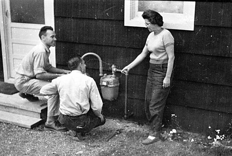 Photo provided by the KPC archive of historical photographs 
Ed Back, left, and Bill Gross chat with Ridgeway homeowner Betty Karsten as they install a natural gas hookup to her home in 1961. Betty and Emmett Karsten became Alaska’s first civilian consumers of natural gas.