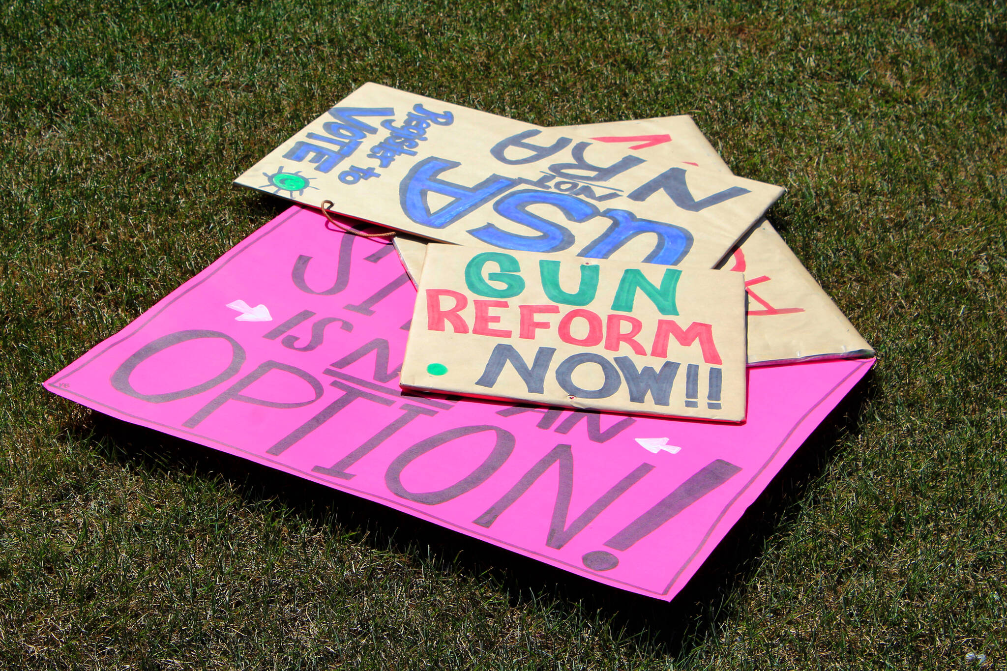 Signs are stacked on the ground during a demonstration opposing gun violence on Saturday, June 11, 2022, in Soldotna, Alaska. The local protest was part of a nationwide call to action issued by the nonprofit organization March for Our Lives, which was formed after a 2018 school shooting in Parkland, Florida, and aims to end gun violence. (Ashlyn O’Hara/Peninsula Clarion)
