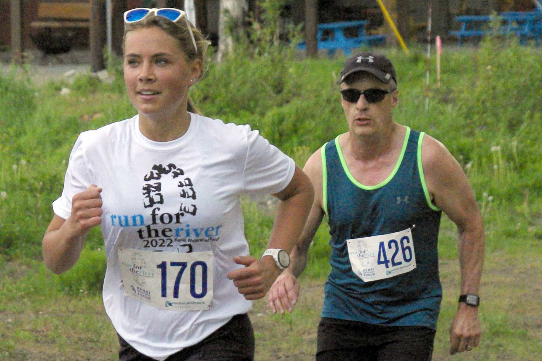 Jordan Strausbaugh, trailed by Ken Youngberg, runs to victory in the women's 5-kilometer race Saturday, June 11, 2022, at the Run for the River in Soldotna, Alaska. (Photo by Jeff Helminiak/Peninsula Clarion)