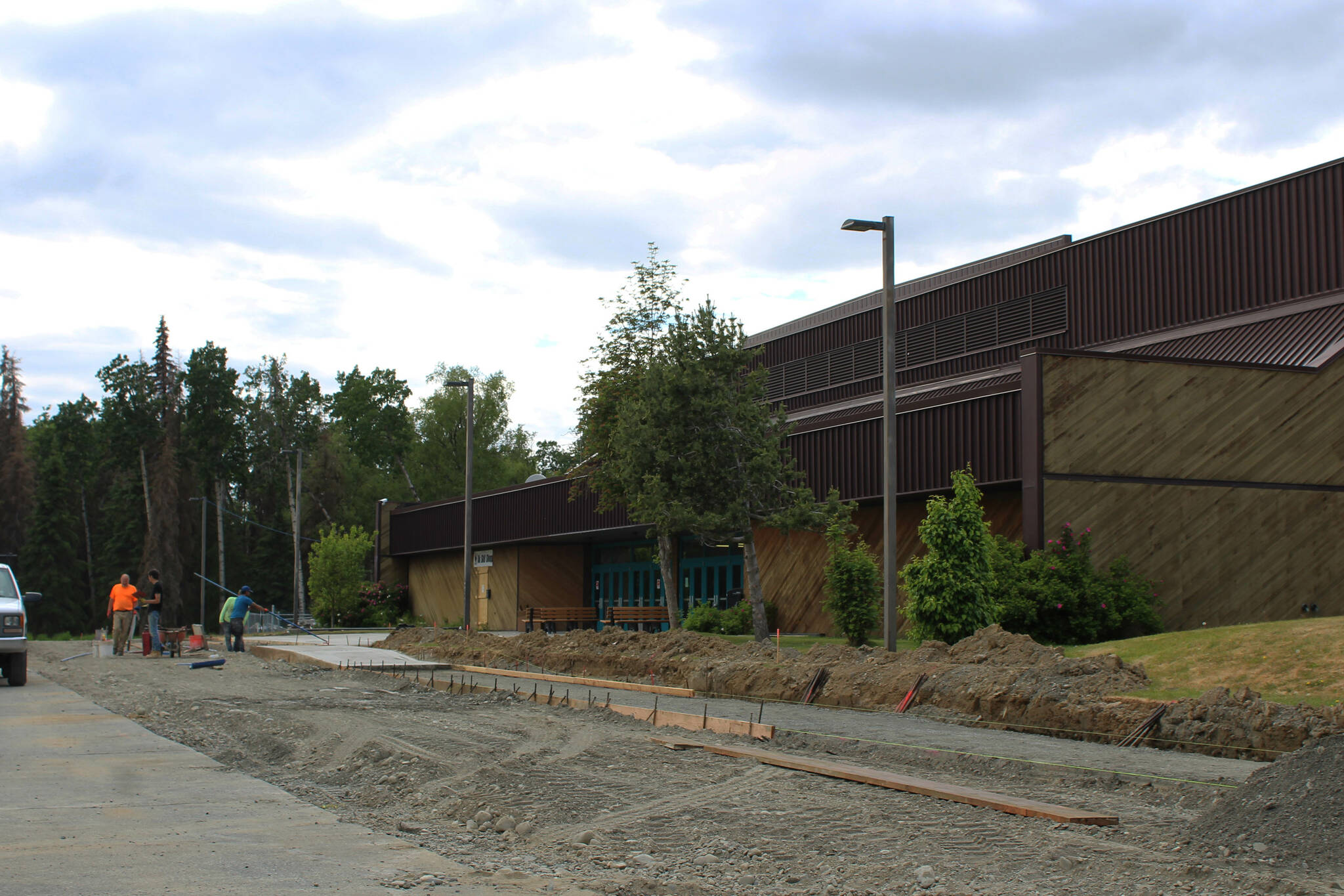 A construction crew works near the entrance of the Soldotna Regional Sports Complex on Tuesday, June 14, 2022 in Soldotna, Alaska. (Ashlyn O’Hara/Peninsula Clarion)