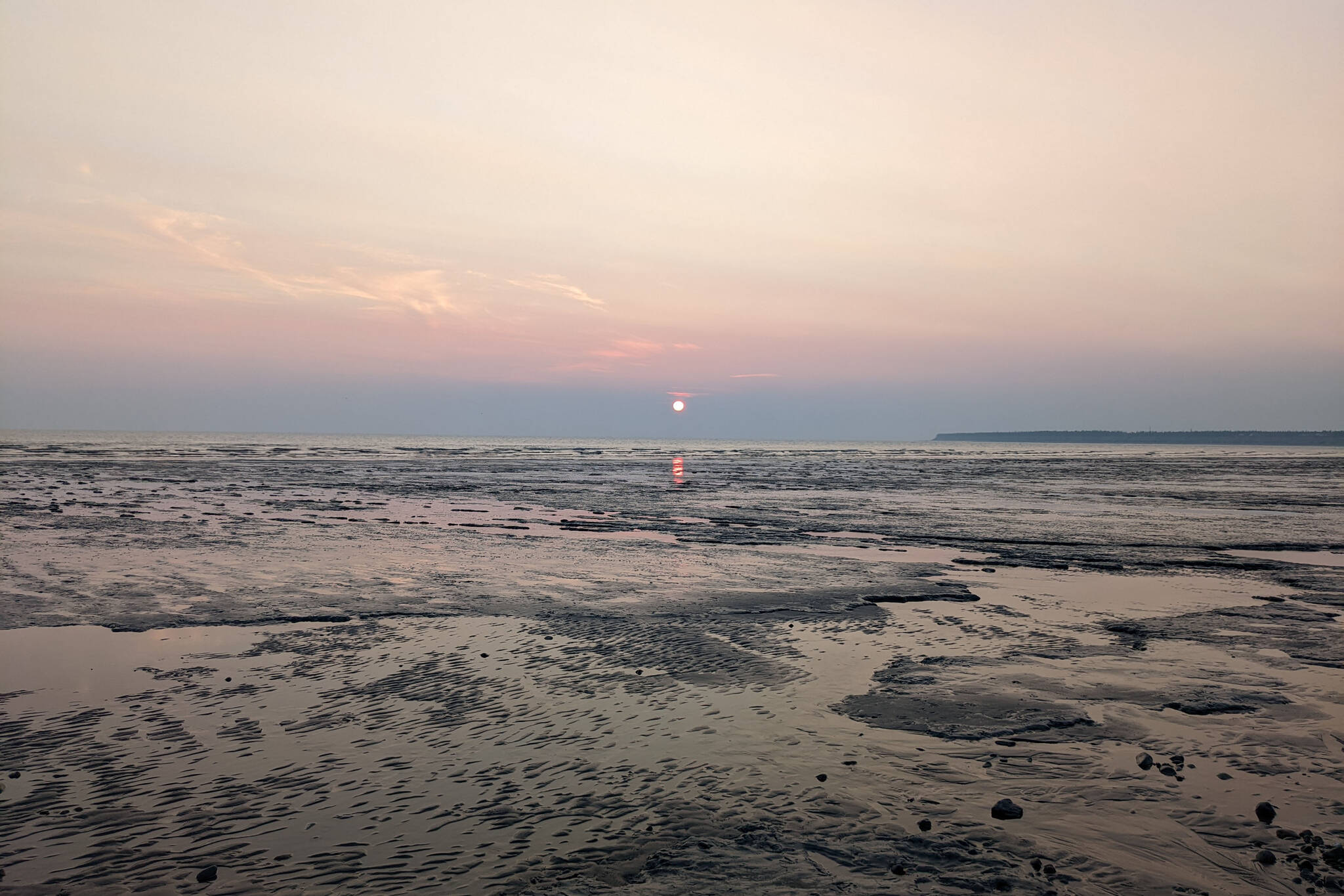 Hazy skies are seen as the sun sets on Cook Inlet, seen from South Kenai Beach, on Sunday, June 12, 2022. Wildfires in western Alaska pushed smoke to the Southcentral area over the weekend. (Photo by Erin Thompson/Peninsula Clarion)