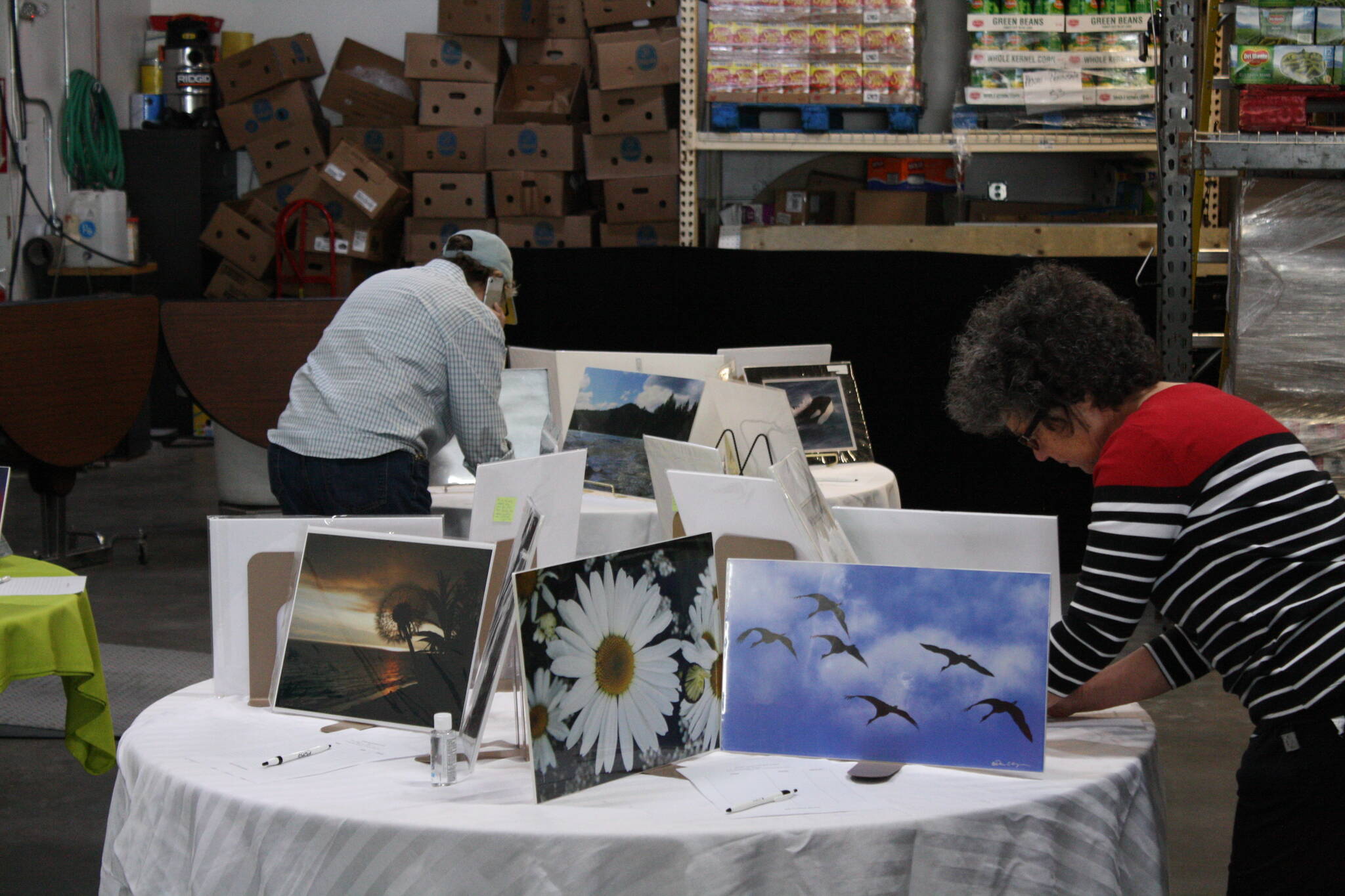 Artwork up for auction is displayed at the Kenai Peninsula Food Bank as part of its Spring Festival celebration on Thursday, June 16, 2022. (Camille Botello/Peninsula Clarion)