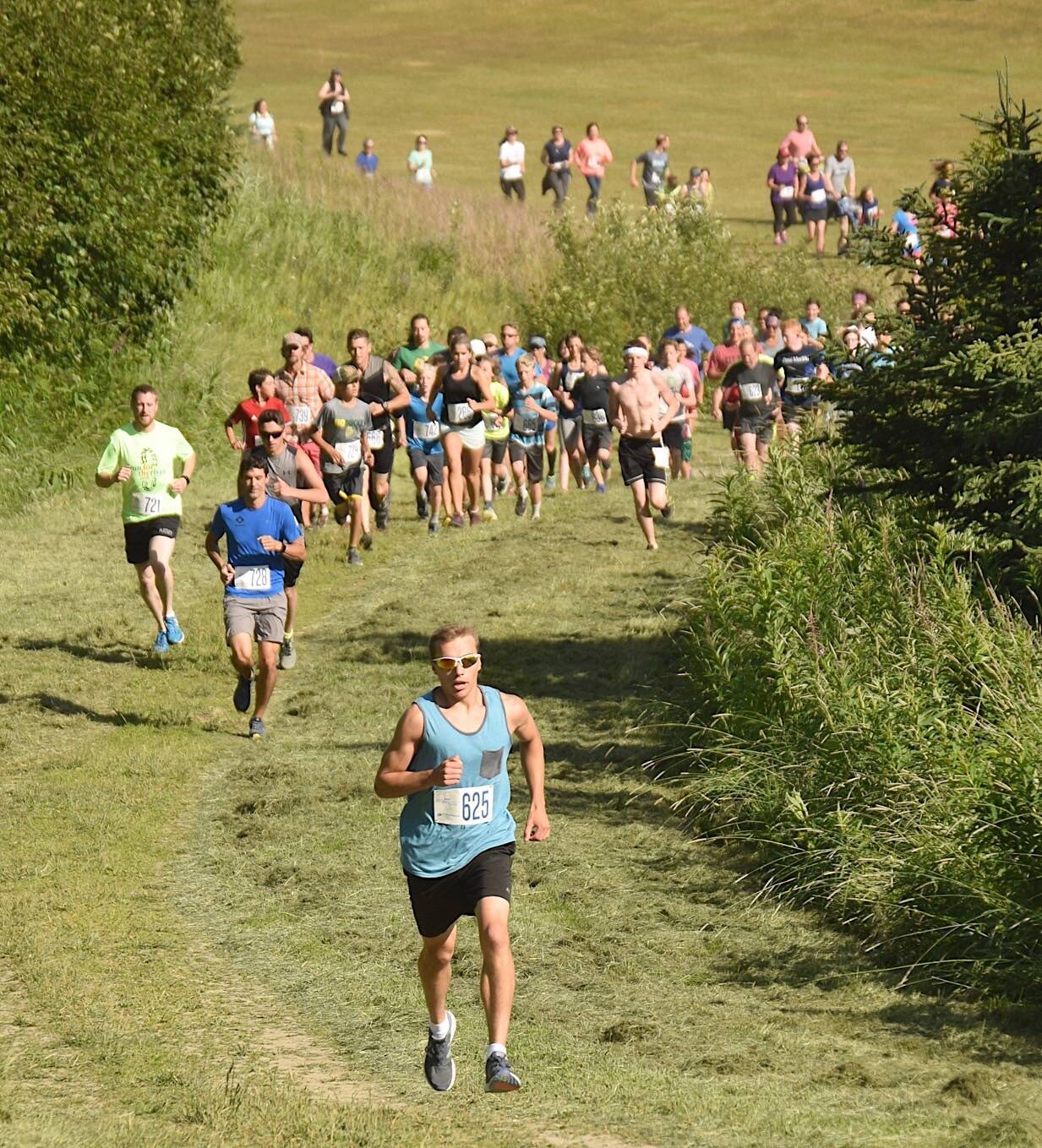 Bradley Walters leads the pack up Angle Hill on Wednesday, July 18, 2018, at the Salmon Run Series at Tsalteshi Trails. (Photo by Jeff Helminiak/Peninsula Clarion)