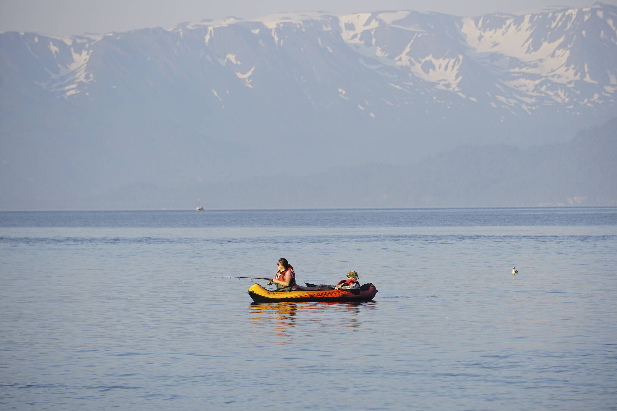 People in an inflatable kayak fish off the end of the Homer Spit on Thursday, June 23, 2022, in Homer, Alaska. (Photo by Michael Armstrong/Homer News)