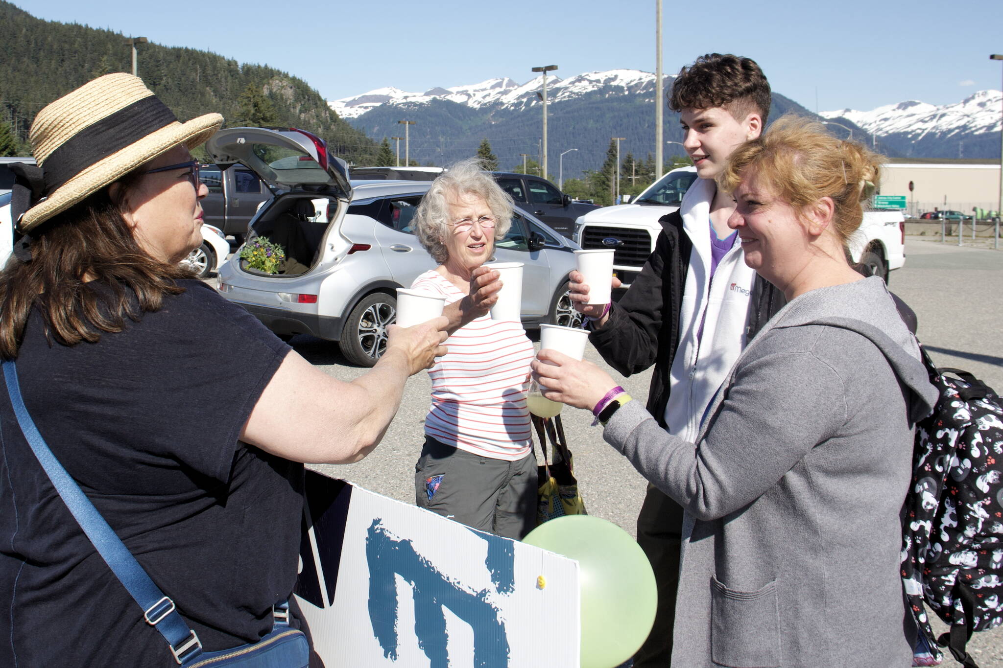Iryna Hrynchenko and her 18 year old son, Ivan Hrynchenko, 18, Joyanne Bloom and Bridget Smith toast to the Ukrainians’ arrival Saturday, June 25, 2022, at Juneau Airport. Bloom and Smith are part of a five-person group of residents who raised funds to bring the Hrynchenkos to Juneau, and is helping them with housing, education and job opportunities, and in other ways. (Mark Sabbatini / Juneau Empire)