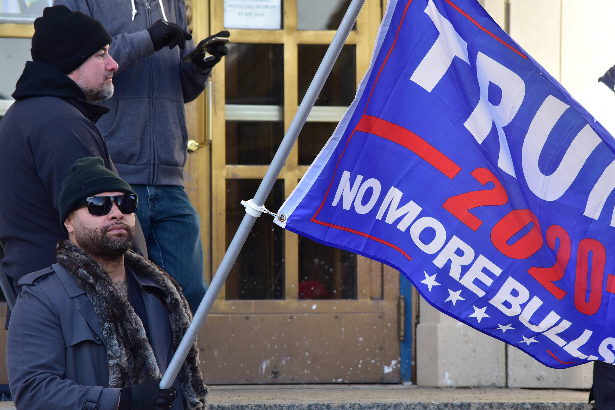 In this Nov. 7, 2020, photo Jaimie Sekona holds a Trump flag on the steps of the Alaska State Capitol. The former president is scheduled to speak Saturday afternoon at a rally in Anchorage. (Peter Segall / Juneau Empire File)