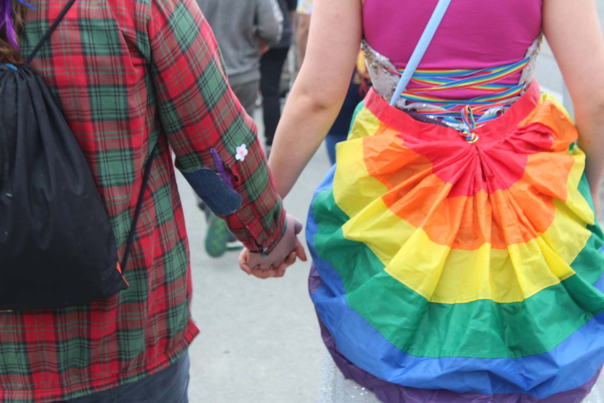 Community members gather in Soldotna on Friday, June 17, 2022 to celebrate Pride month. People marched from the Soldotna Sports Complex to Soldotna Creek Park donned in rainbow-colored attire and wielding flags and signs supporting the LGBTQI+ cause. Waiting at the park were people with different advocacy and resource agencies, as well as entertainment and refreshments. (Camille Botello/Peninsula Clarion)