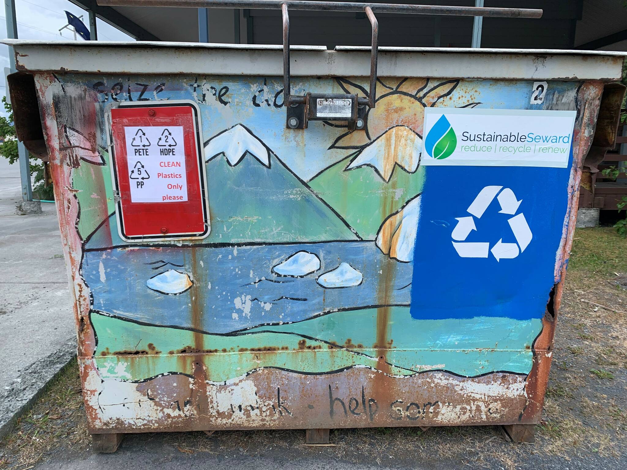 Recycling signage is displayed on an upscaled dumpster used to collect plastics as part of a project to turn discarded plastic waste into artificial lumber, in Seward, Alaska. (Photo courtesy Lori Landstrom)