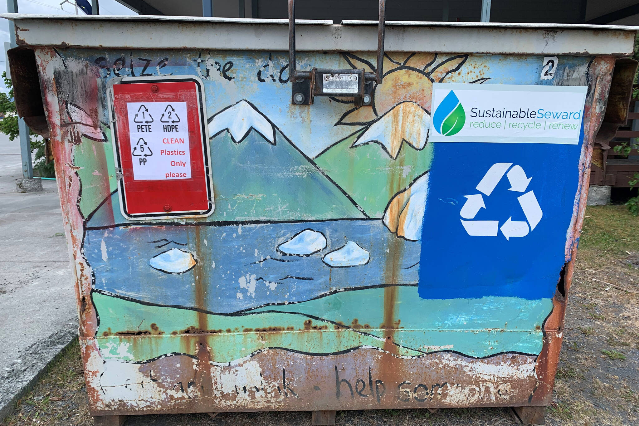 Recycling signage is displayed on an upscaled dumpster used to collect plastics as part of a project to turn discarded plastic waste into artificial lumber, in Seward, Alaska. (Photo courtesy Lori Landstrom)