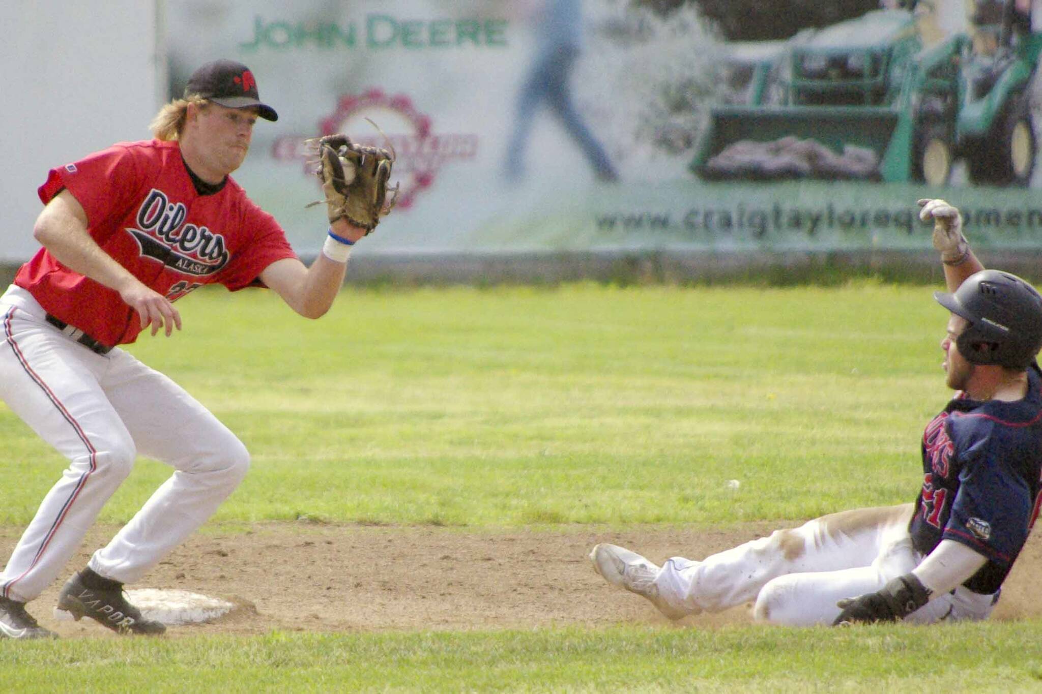 OIlers second baseman Graiden West gets ready to tag out Justin Grech of the Chugiak-Eagle River Chinooks on a steal attempt Sunday, July 10, 2022, at Coral Seymour Memorial Park in Kenai, Alaska. (Photo by Jeff Helminiak/Peninsula Clarion)
