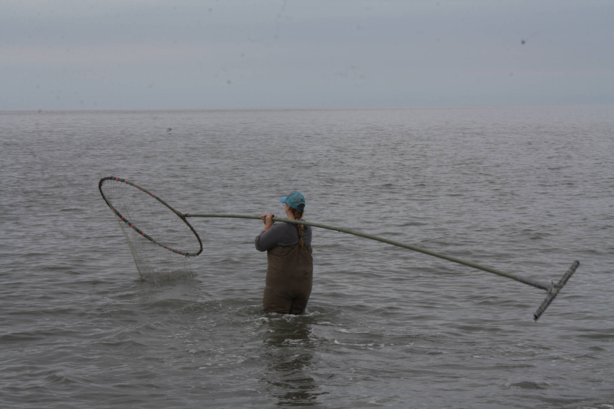 Kristen Stearns fishes at North Kenai Beach on Tuesday, July 12, 2022. (Camille Botello/Peninsula Clarion)