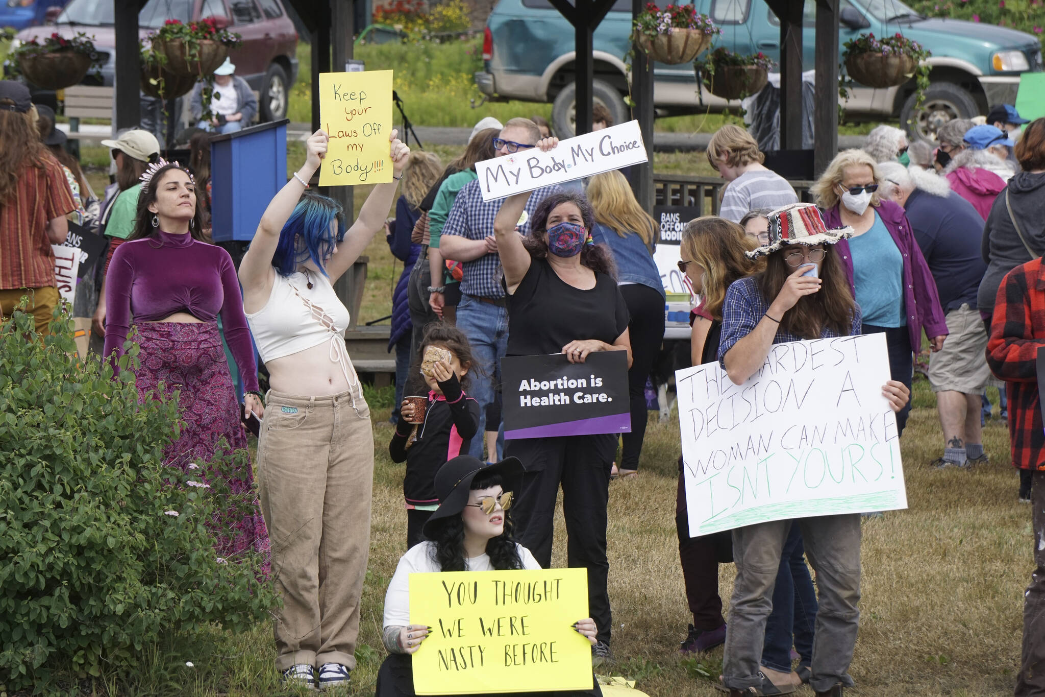 People hold signs at the "Women's March: Bans Off Our Bodies" protest on Saturday, July 9, 2022, at WKFL Park in Homer, Alaska. (Photo by Michael Armstrong/Homer News)