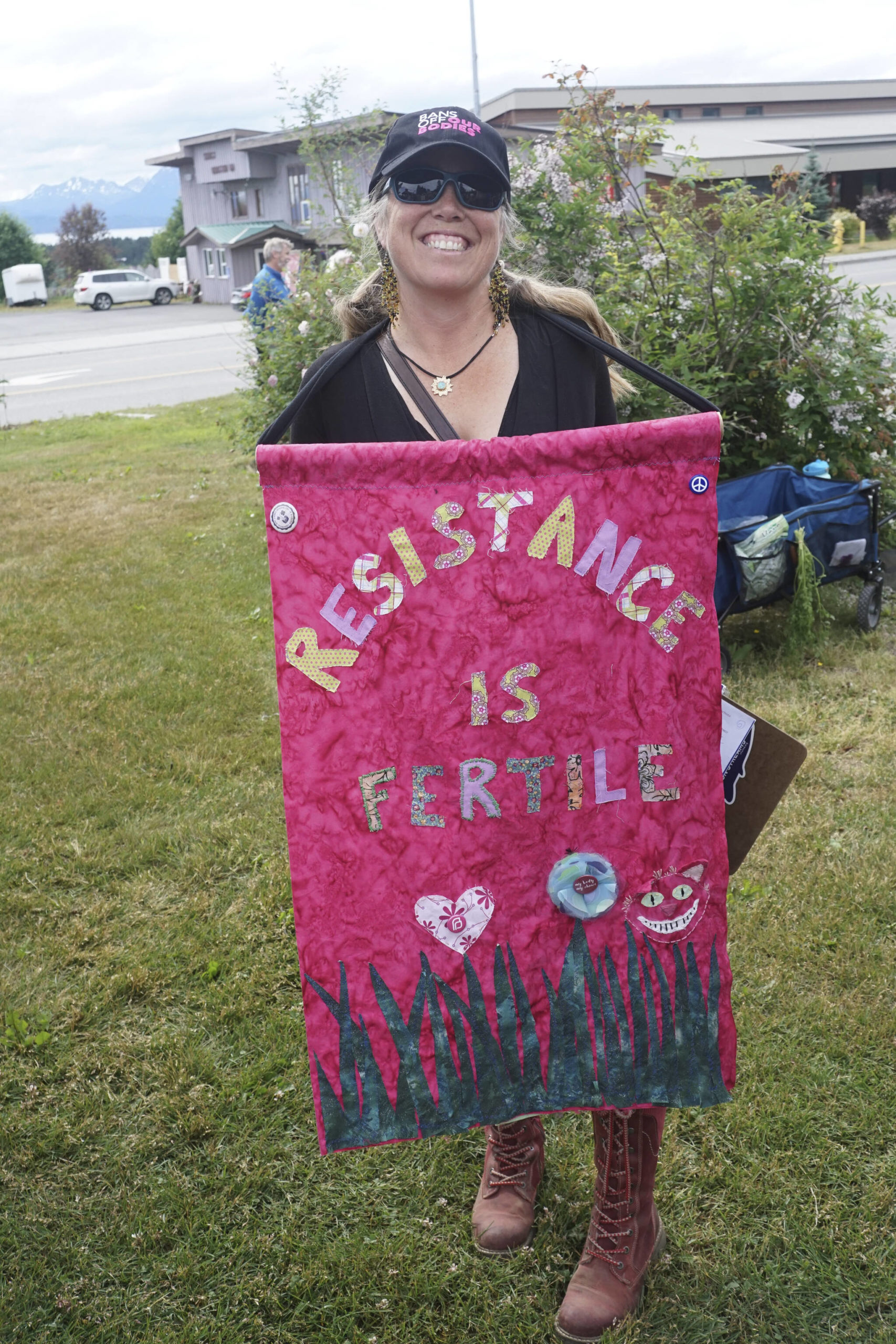 Carly Wier holds a sign that reads "Resistance is Fertile" at the "Women's March: Bans Off Our Bodies" protest on Saturday, July 9, 2022, at WKFL Park in Homer, Alaska. (Photo by Michael Armstrong/Homer News)