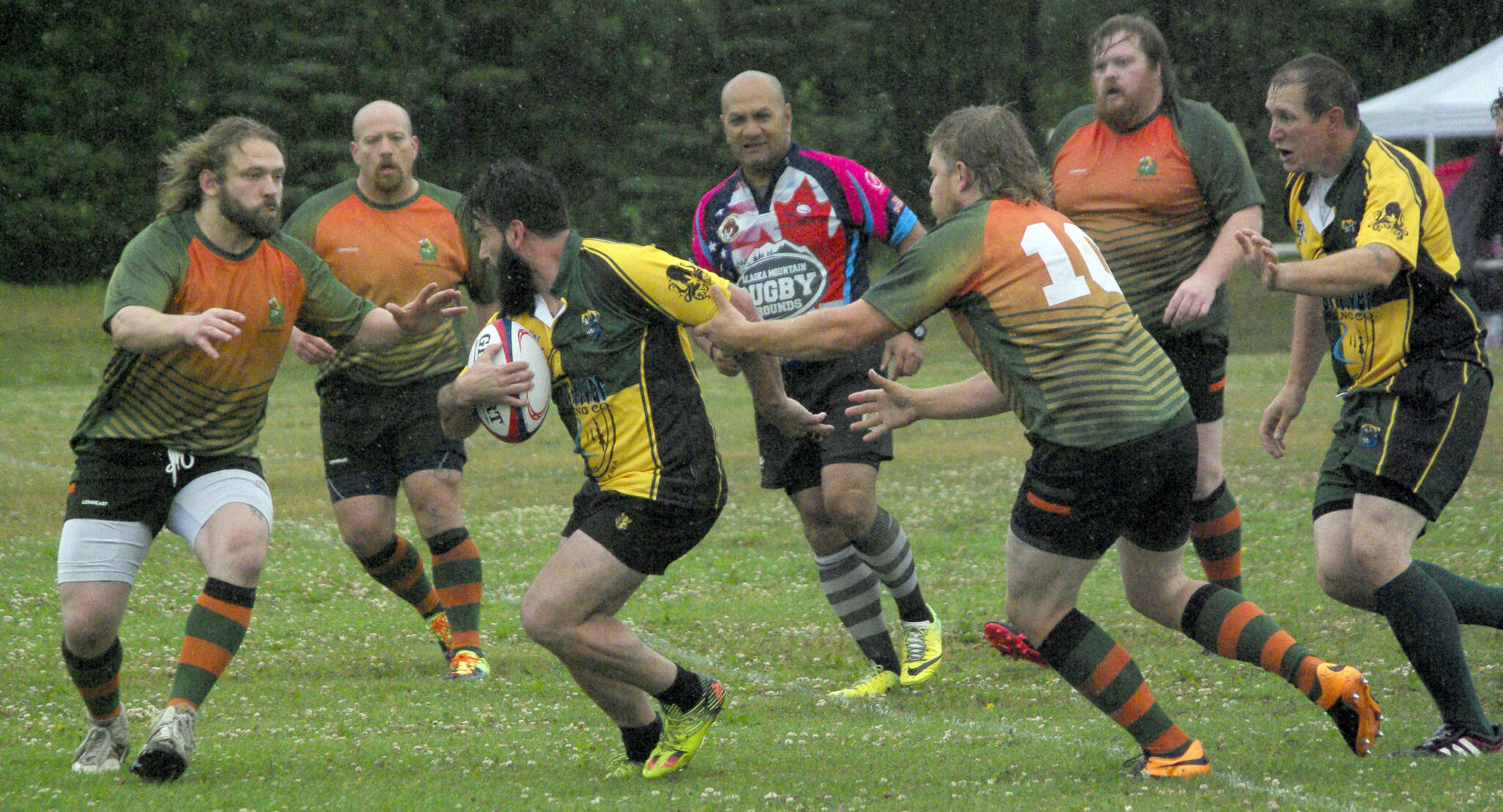 Ryan Childers of the Kenai River Wolfpack tries to evade Hermit CRABS players Sam “Sue” Warner (front) and Steven Ganley on Saturday, July 16, 2022, at the 2022 Kenai Dipnet Fest Rugby Tournament at Millennium Square in Kenai, Alaska. (Photo by Jeff Helminiak/Peninsula Clarion)