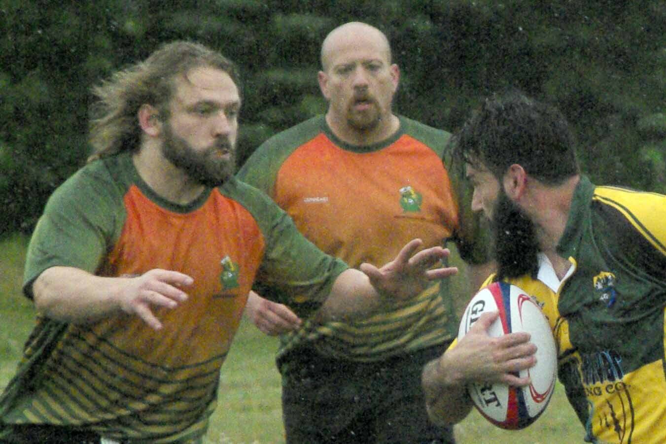 Ryan Childers of the Kenai River Wolfpack tries to evade Hermit CRABS players Sam "Sue" Warner (front) and Steven Ganley on Saturday, July 16, 2022, at the 2022 Kenai Dipnet Fest Rugby Tournament at Millennium Square in Kenai, Alaska. (Photo by Jeff Helminiak/Peninsula Clarion)