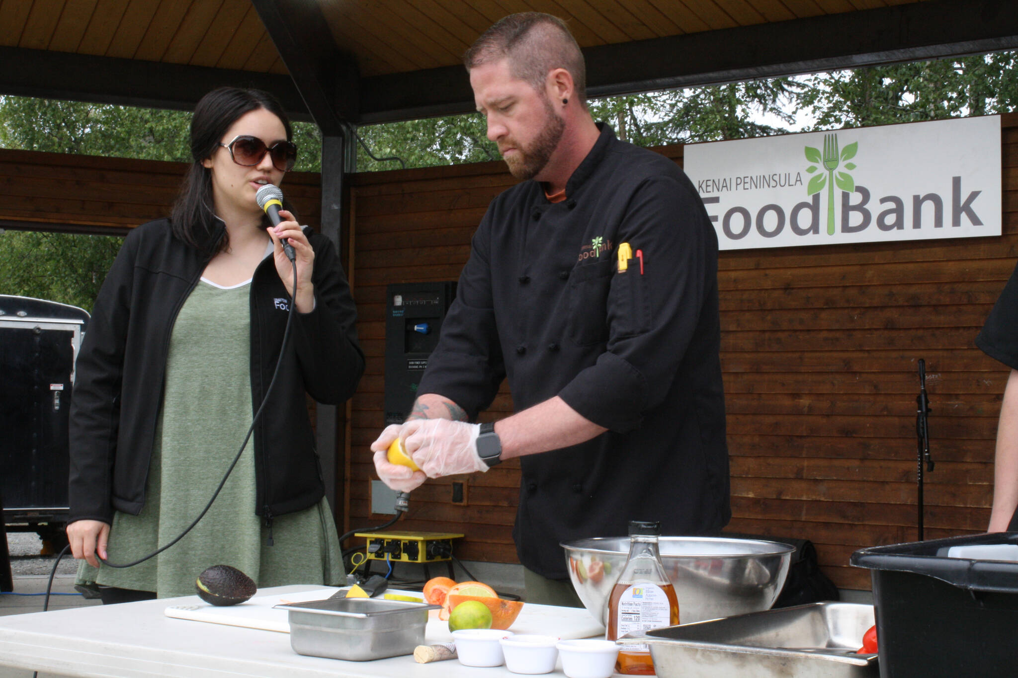 Lilly Murray, left, and Stephen Lamm from the Kenai Peninsula Food Bank give a ceviche-making demonstration at Soldotna Creek Park on Thursday, July 21, 2022. (Camille Botello/Peninsula Clarion)