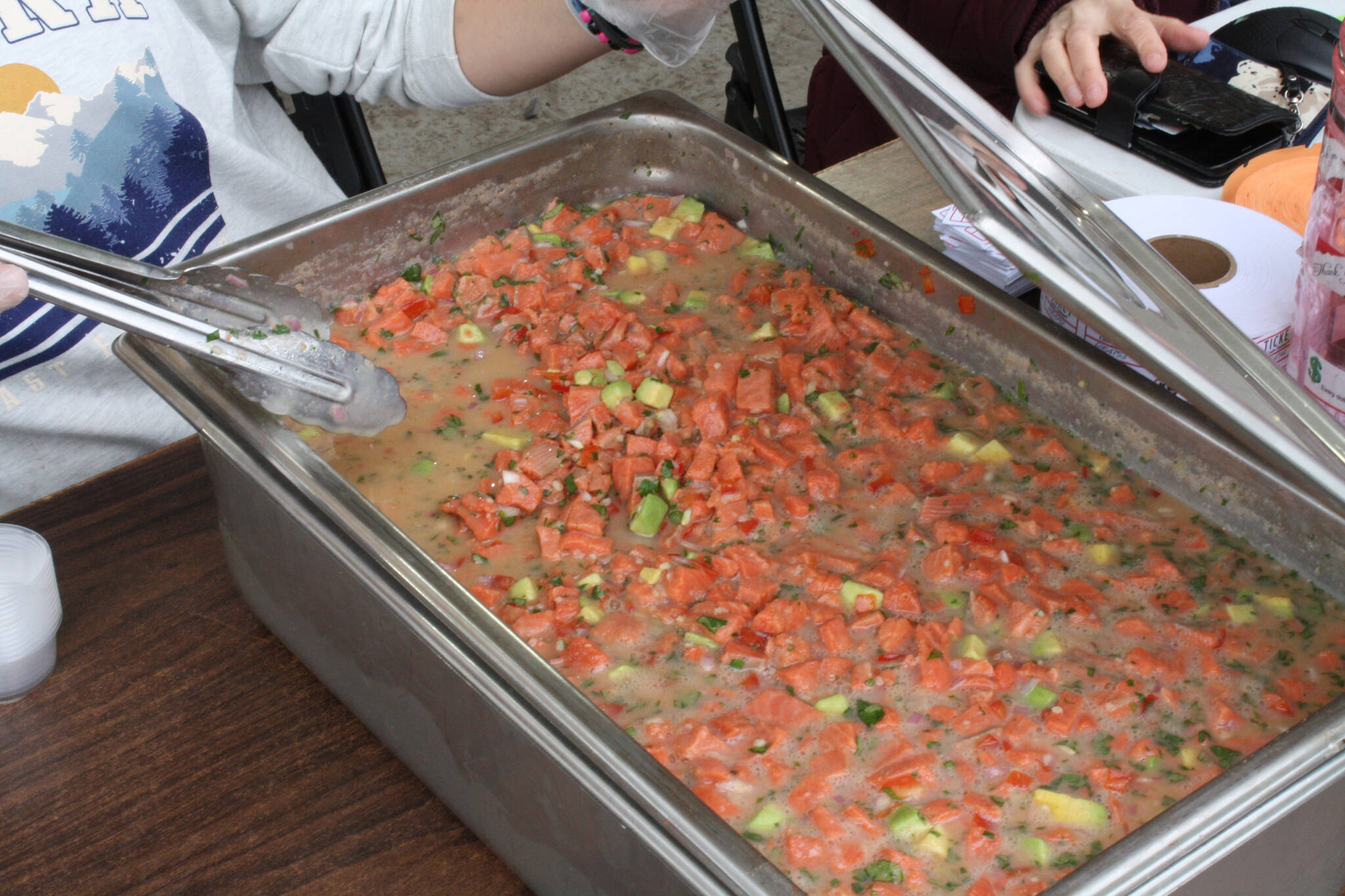 Kenai Peninsula Food Bank volunteers serve ceviche during their fundraiser at Soldotna Creek Park on Thursday, July 21, 2022. (Camille Botello/Peninsula Clarion)