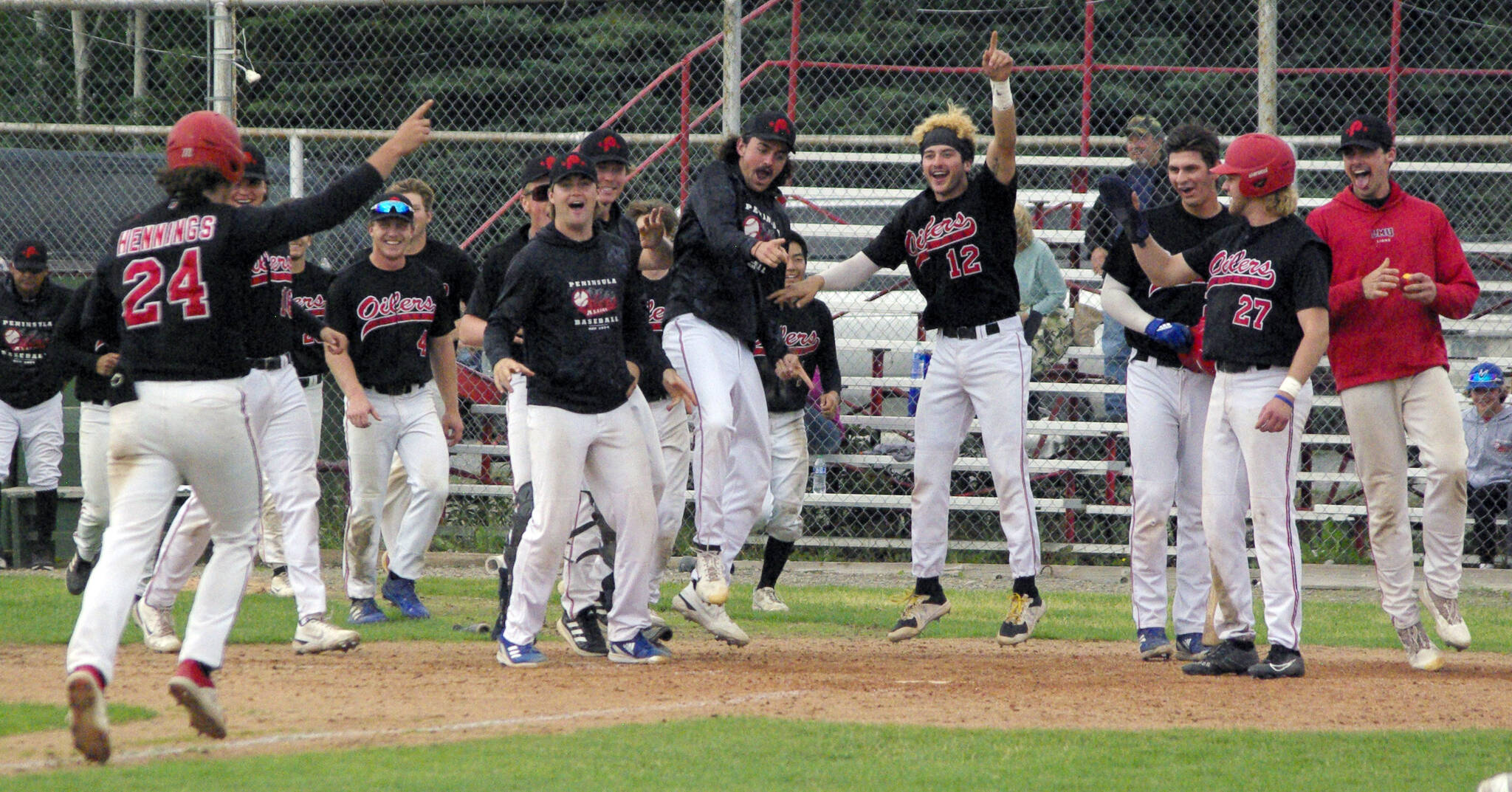 The Peninsula Oilers celebrate a home run by Noah Hennings against the Anchorage Bucs on Sunday, July 24, 2022, at Coral Seymour Memorial Park in Kenai, Alaska. Hennings hit a two-run homer in the bottom of the seventh to invoke the mercy rule in a 13-3 victory. (Photo by Jeff Helminiak/Peninsula Clarion)