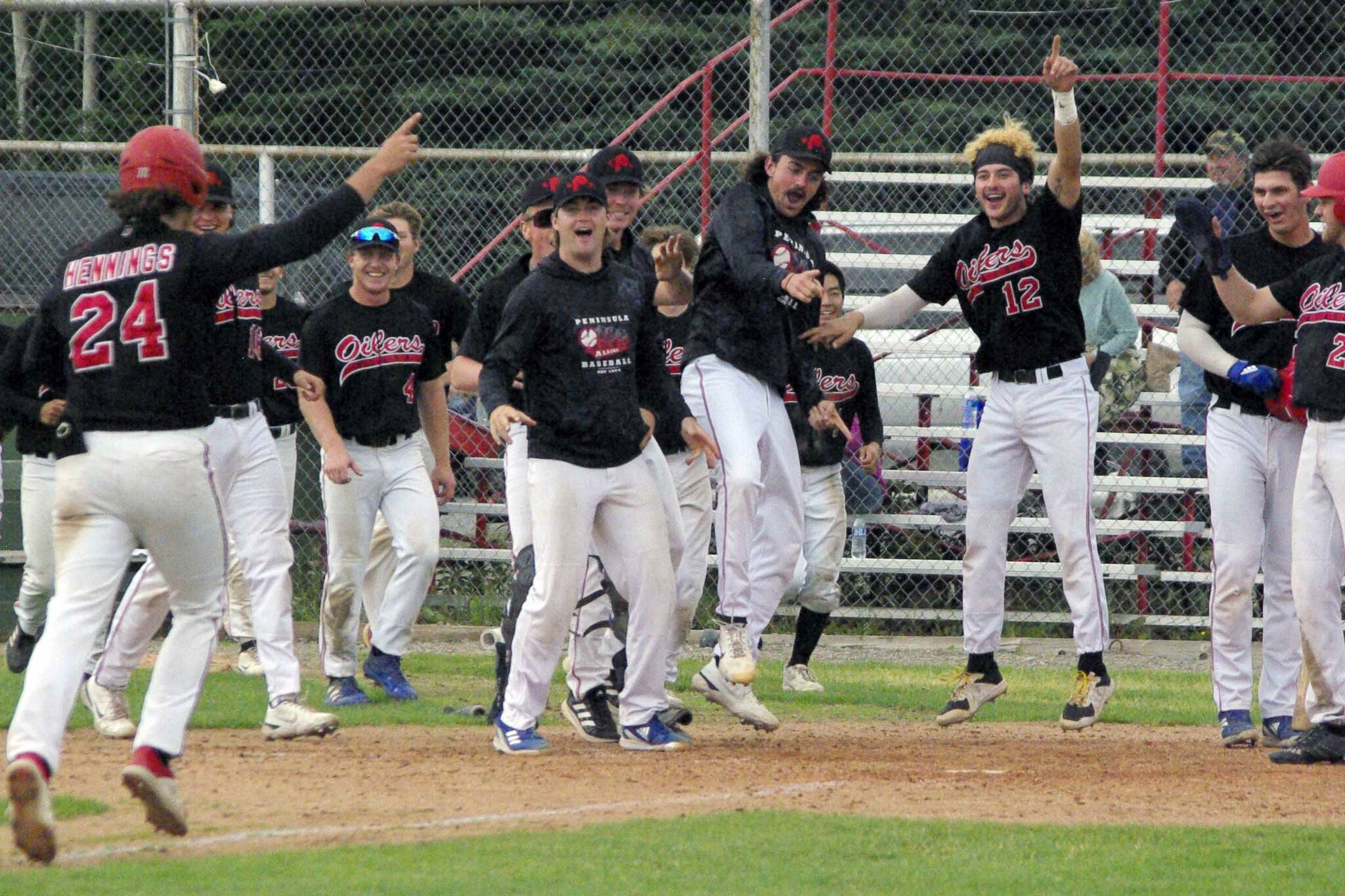 The Peninsula Oilers celebrate a home run by Noah Hennings against the Anchorage Bucs on Sunday, July 24, 2022, at Coral Seymour Memorial Park in Kenai, Alaska. Hennings hit a two-run homer in the bottom of the seventh to invoke the mercy rule in a 13-3 victory. (Photo by Jeff Helminiak/Peninsula Clarion)