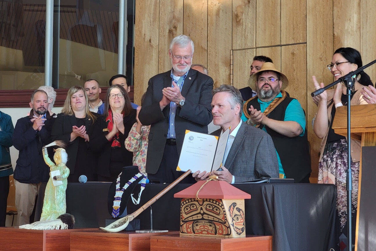 Gov. Mike Dunleavy, center, holds a copy of House Bill 123, providing state recognition for Alaska’s 229 federally recognized Native tribes, at an event hosted by the Alaska Federation of Natives in Anchorage, Alaska, on Thursday, July 28, 2022. (Photo provided by the Alaska Federation of Natives)